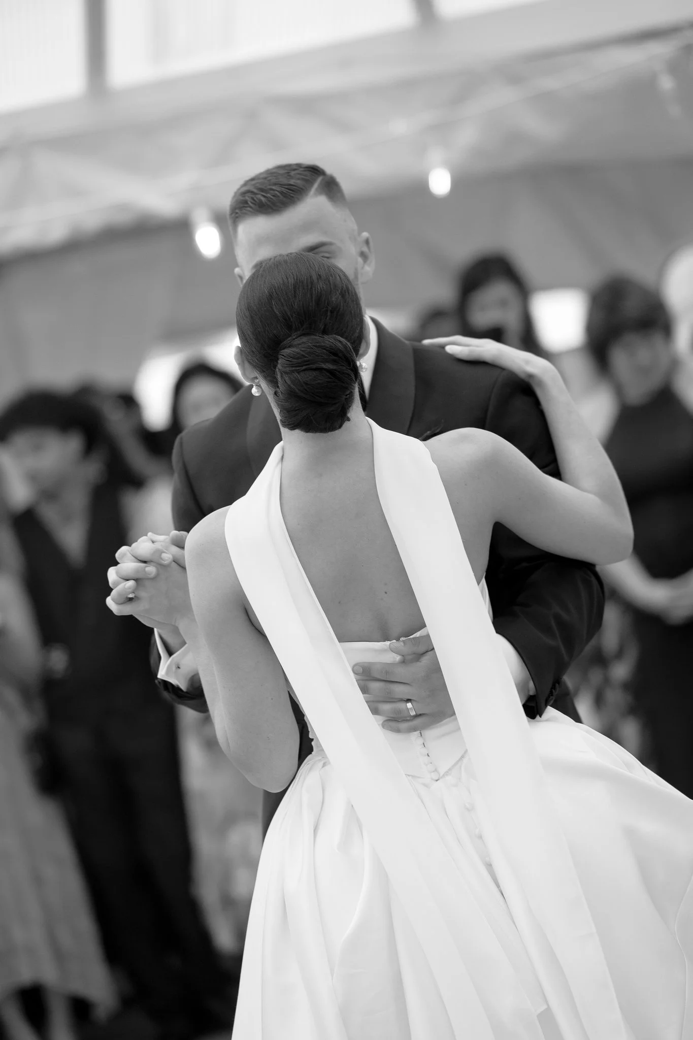 Black-and-white photograph of Hannah and Atticus dancing together at their wedding reception. Photography by Amelie Ferdais.