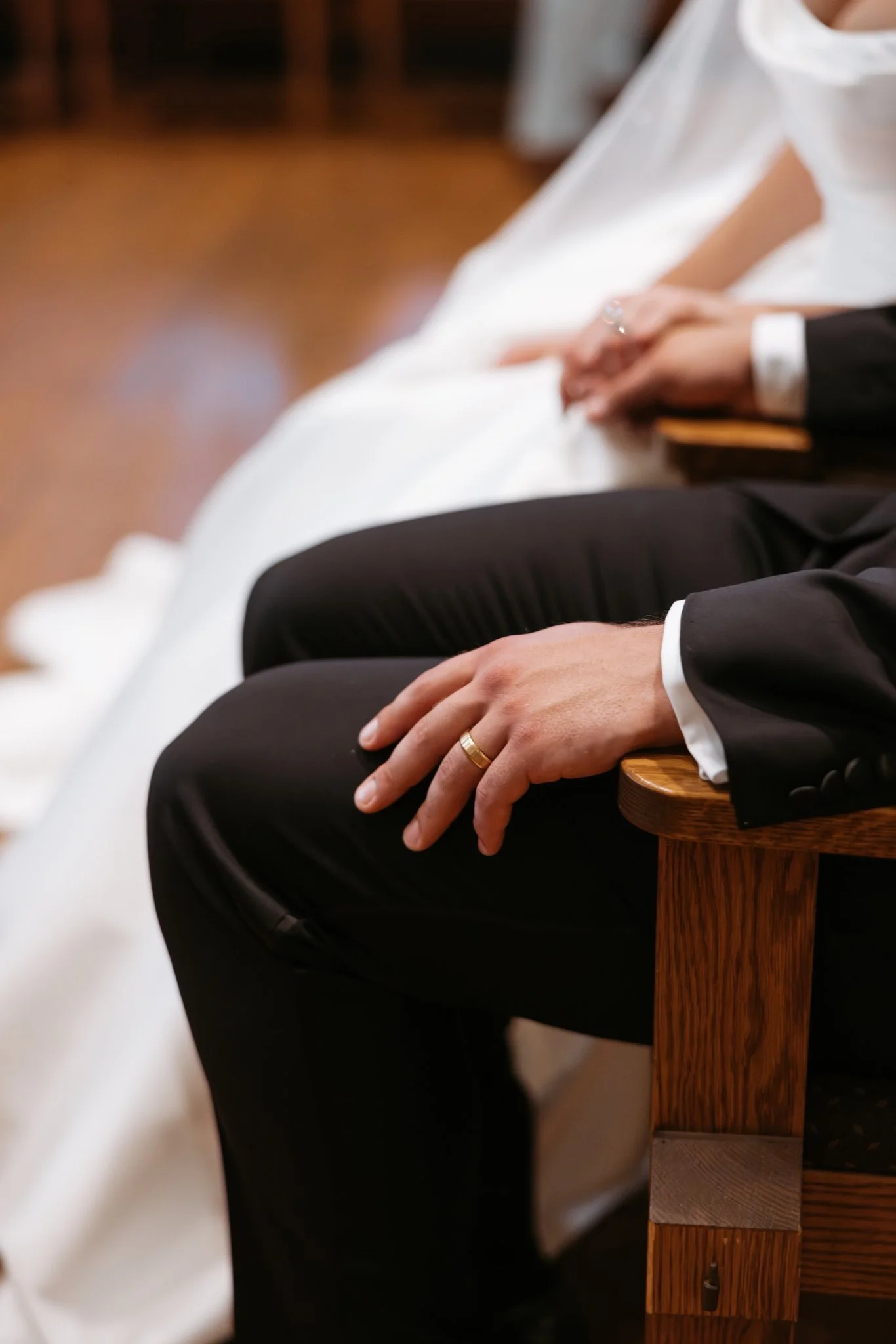 Close-up of Atticus’s wedding band as he sits beside Hannah during their church ceremony. Photography by Amelie Ferdais.