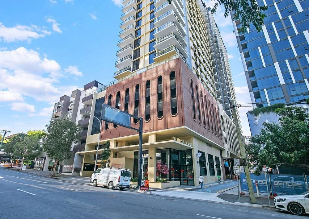 Inner-city apartment towers above street-level shops and restaurants.