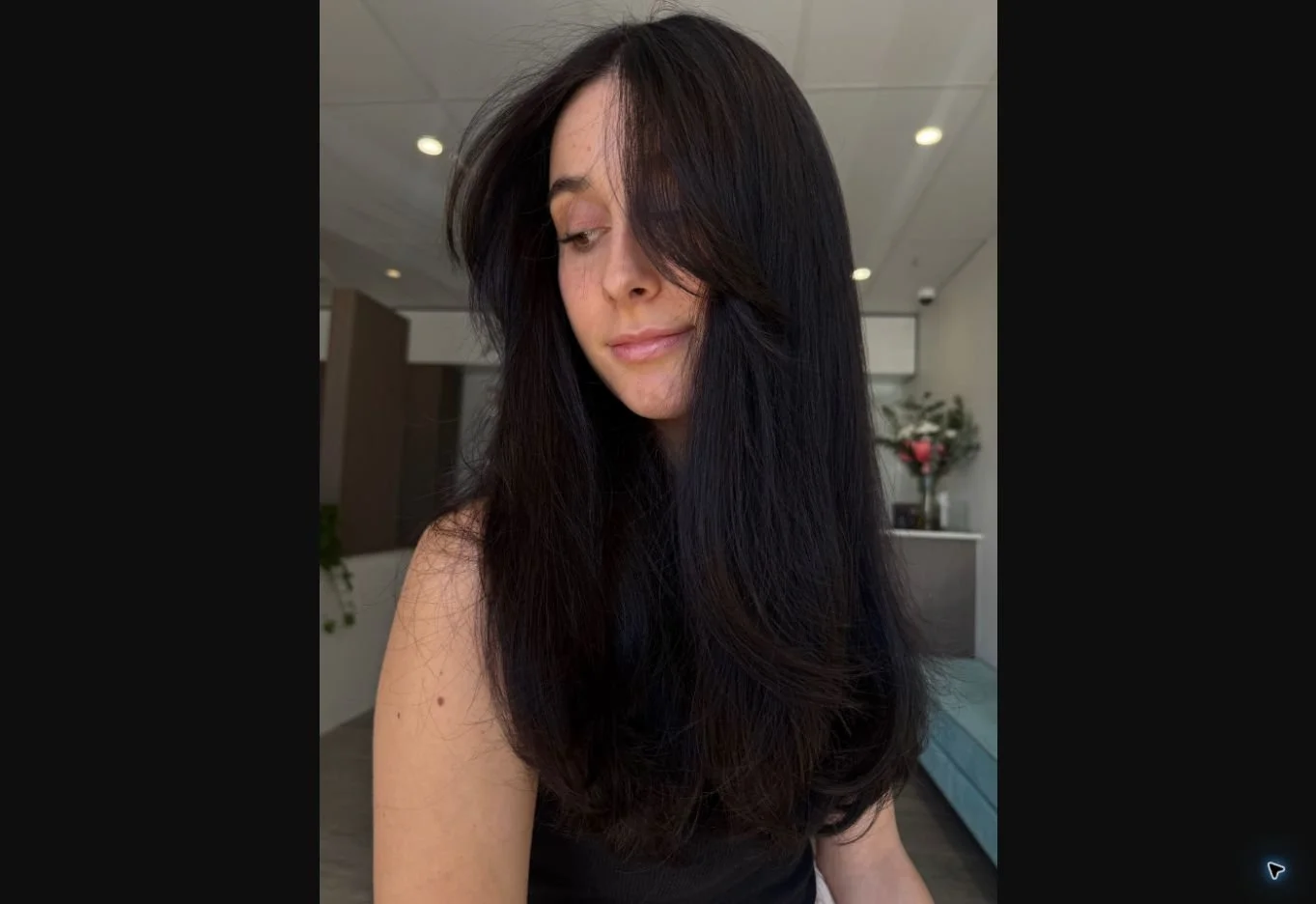 Long glossy brunette hair with soft face-framing layers, styled at Alkemi Salon.
