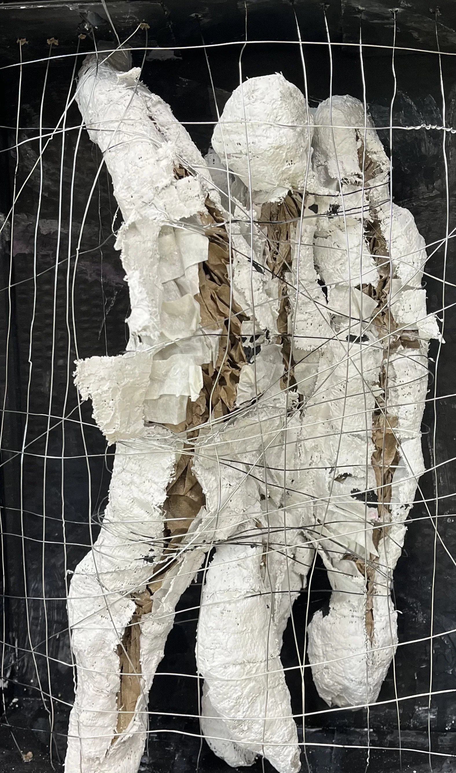 Three Figures with Openings - 11.5" x 14.5" x 4". Cardboard box, newspaper, Plaster of Paris, ink and wire. 