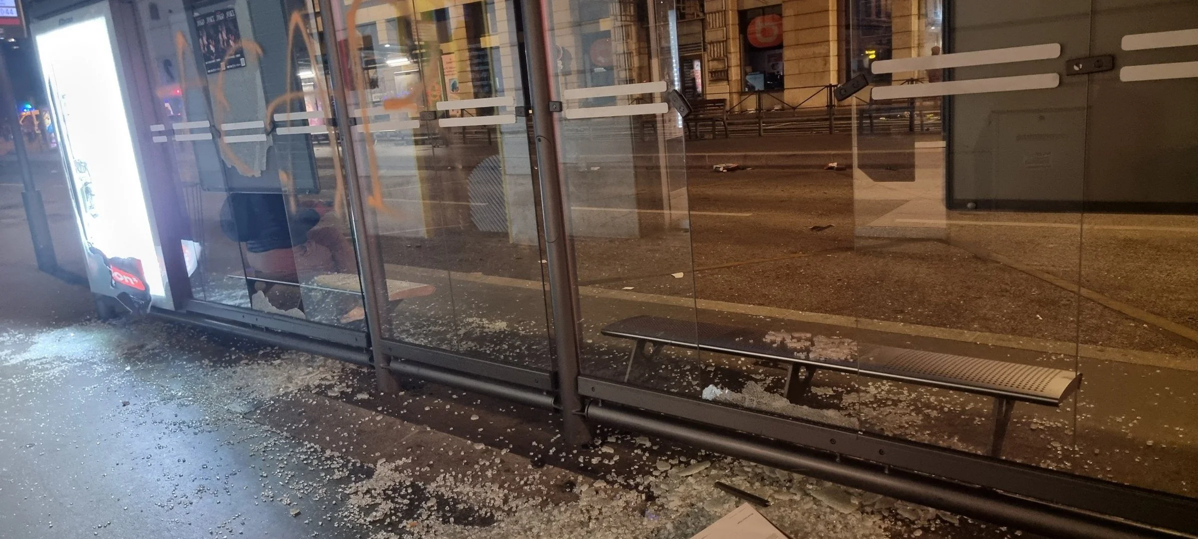 Un abribus aux vitres fracassées, de nuit, dans le centre de Lyon