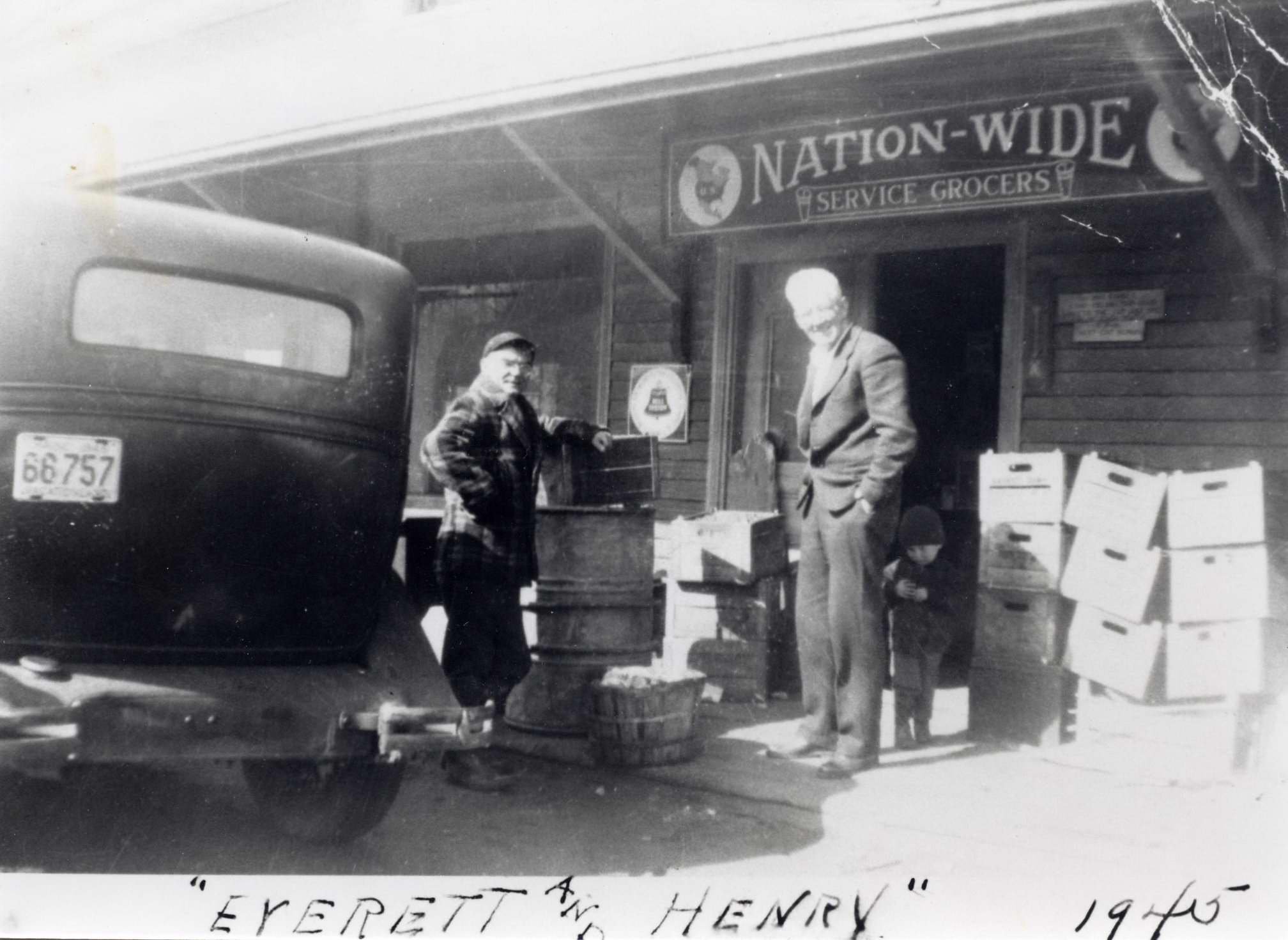 Everett Clarke and Henry MacVane with an unknown child in front of Clarke’s Store, 1945. Gift of Cynthia Ross. 2008.27.2