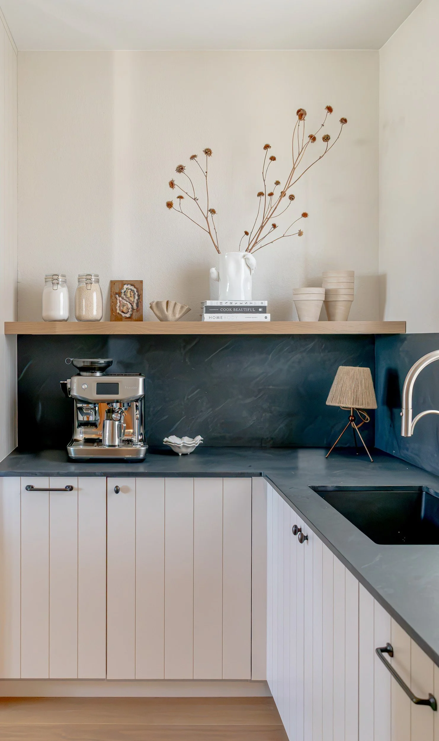 Painted v-groove cabinetry and a coffee station with a floating shelf