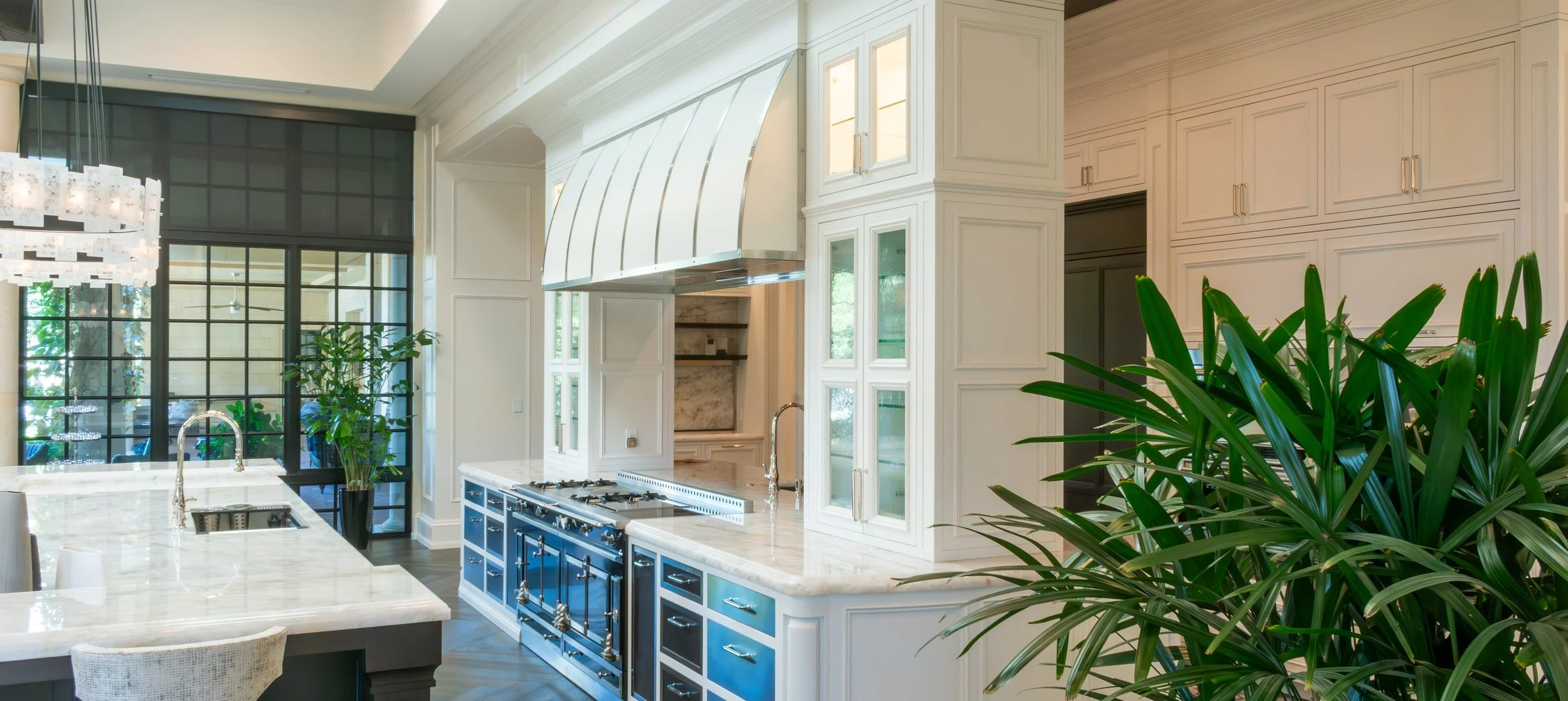 The Two-Island Kitchen: white inset cabinetry, curved range hood and black steel windows