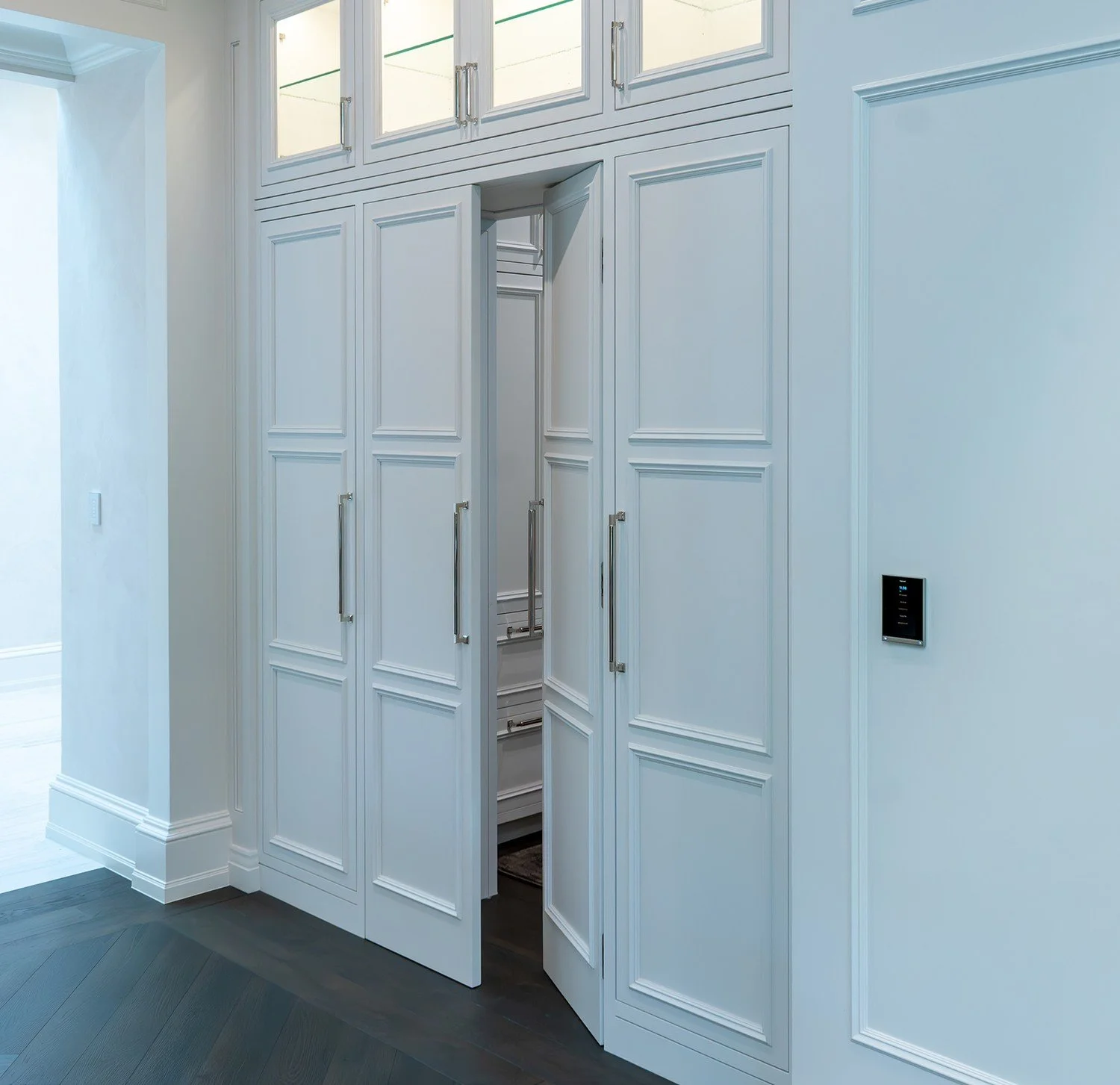 Concealed pantry door within paneled millwork