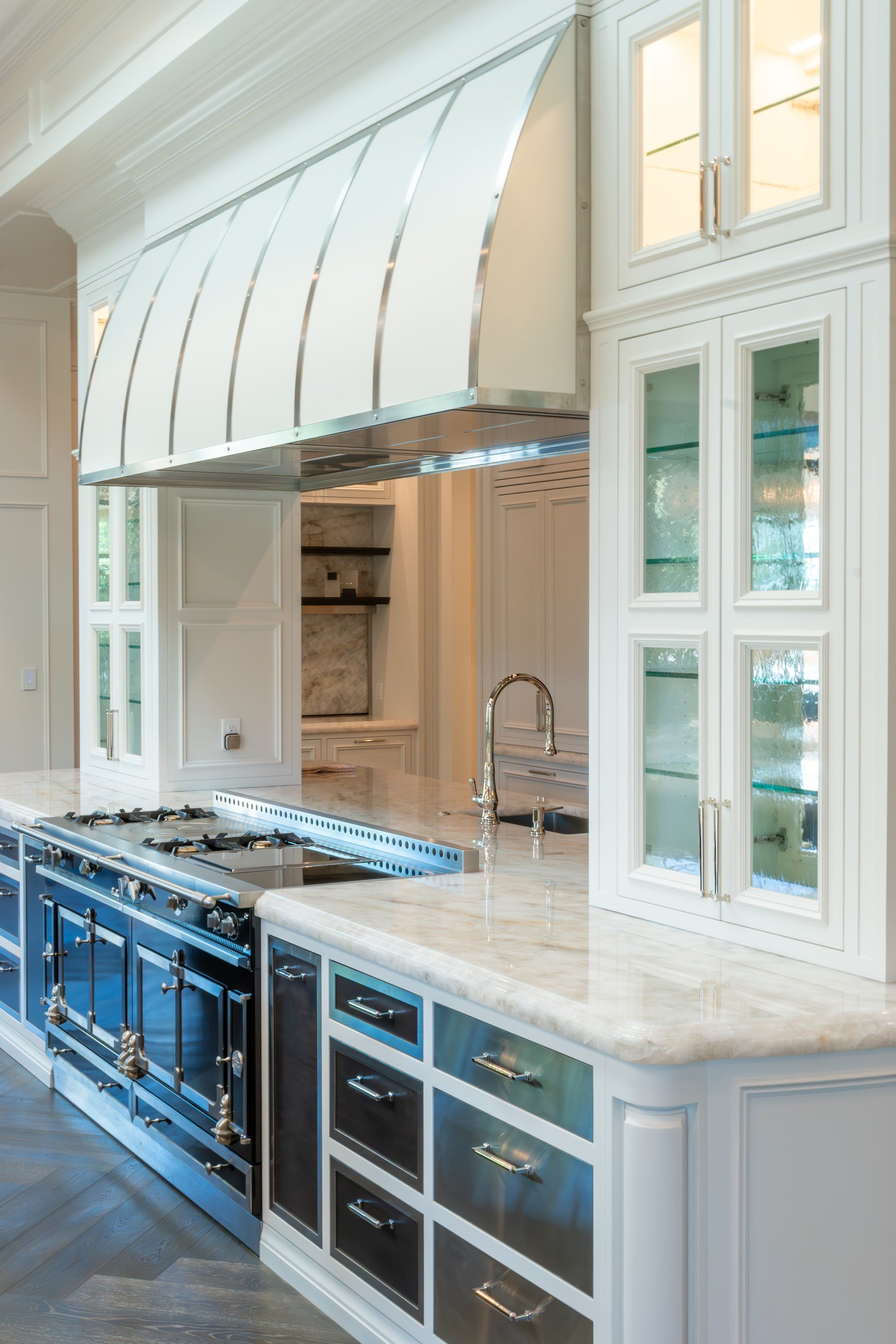Range alcove, curved hood and glass-front cabinets
