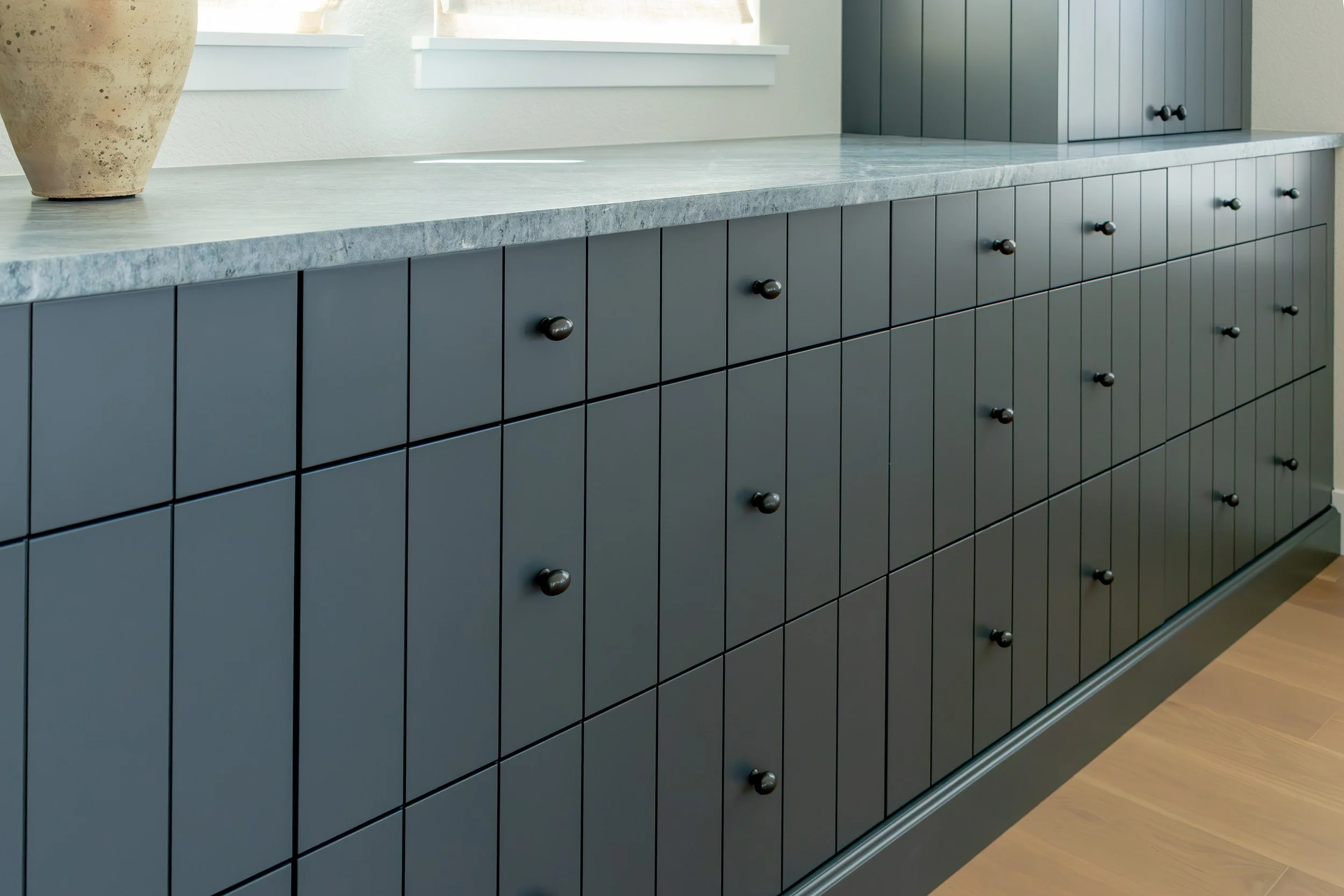 Run of blue-gray drawers under a textured stone top