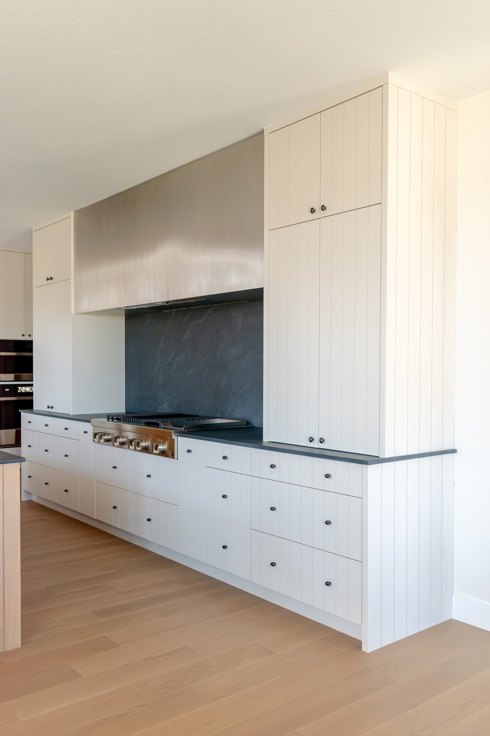 Range wall in cream v-groove cabinetry