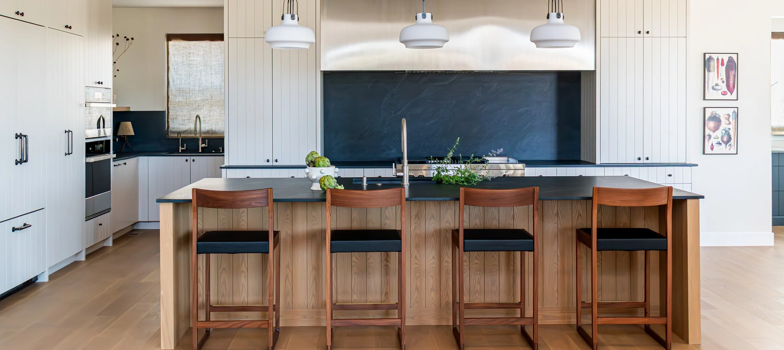 The White Oak Kitchen: oak island with four stools, cream paneled cabinetry and a dark stone backsplash