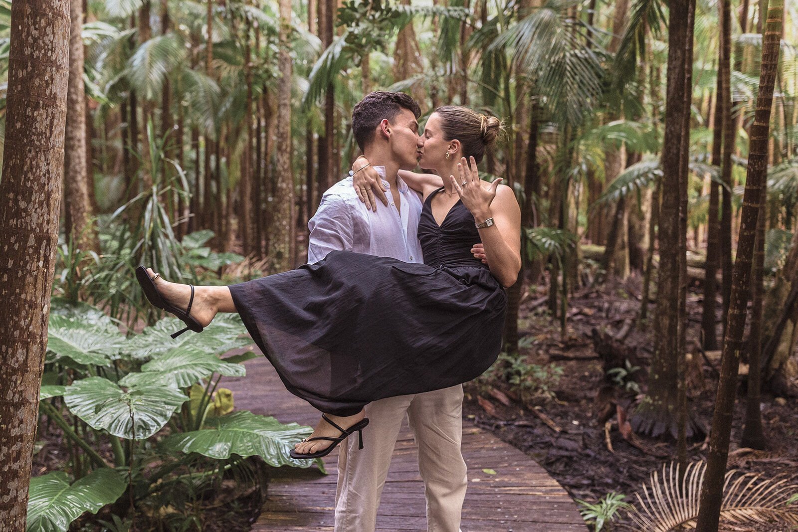 Man carrying his fiancée and kissing her in the forest, Ben and Chloe's marriage proposal in Byron Bay