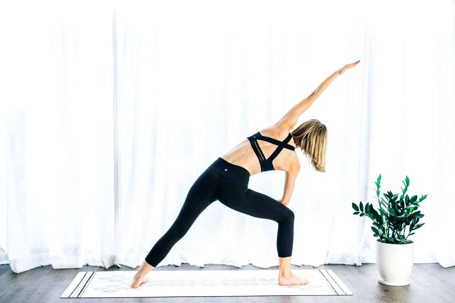 Yoga pose on a mat in a light-filled studio for a yoga and Pilates brand shoot