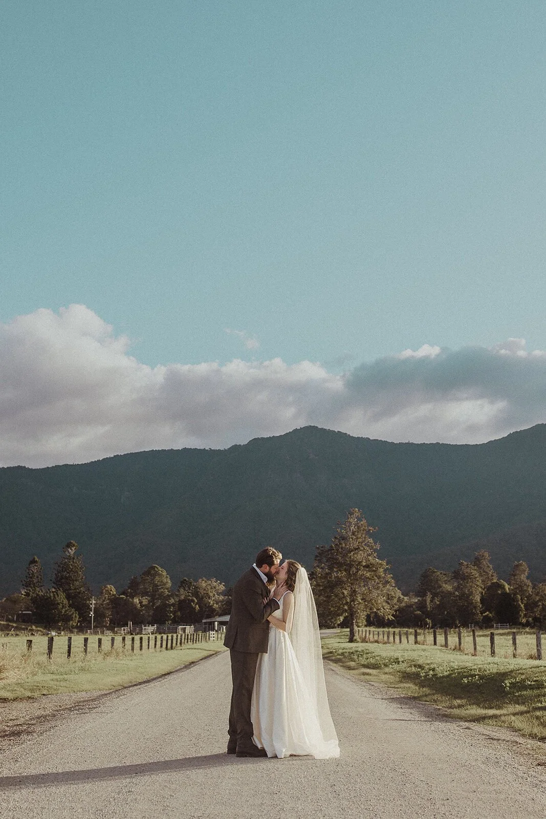 Couple kissing on the road beneath the mountains, Sam and Tom's elopement at Highfield Farm, Northern Rivers