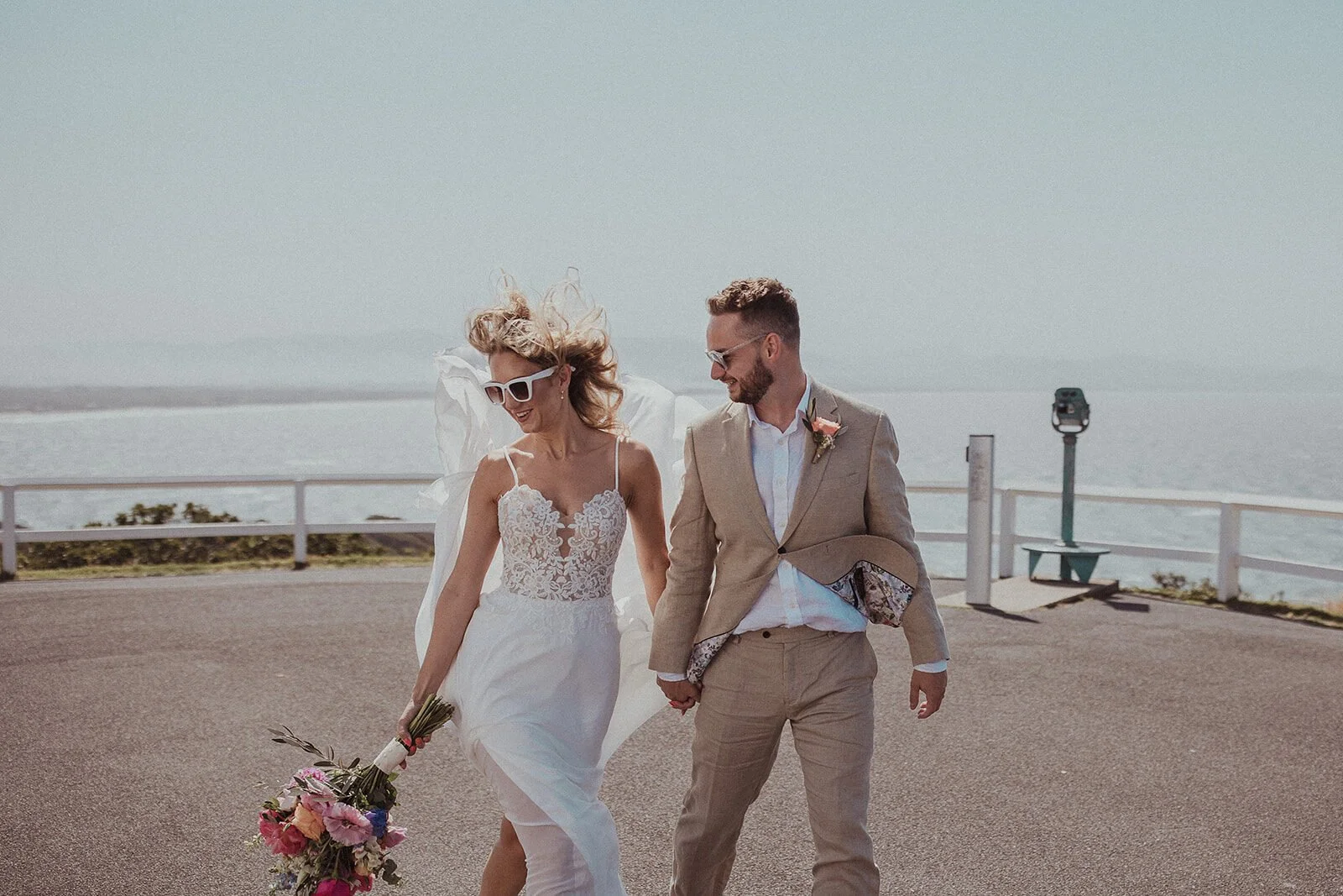 Couple in sunglasses walking at the Cape Byron lookout, Eliza and Greg's elopement at Broken Head, Byron Bay