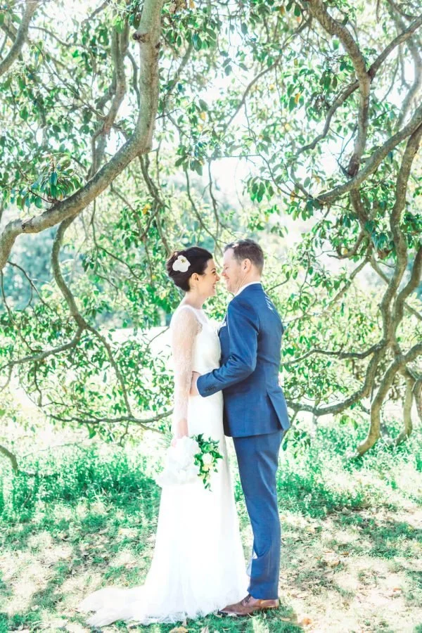 Bride and groom face to face beneath the trees in Centennial Park, Sydney