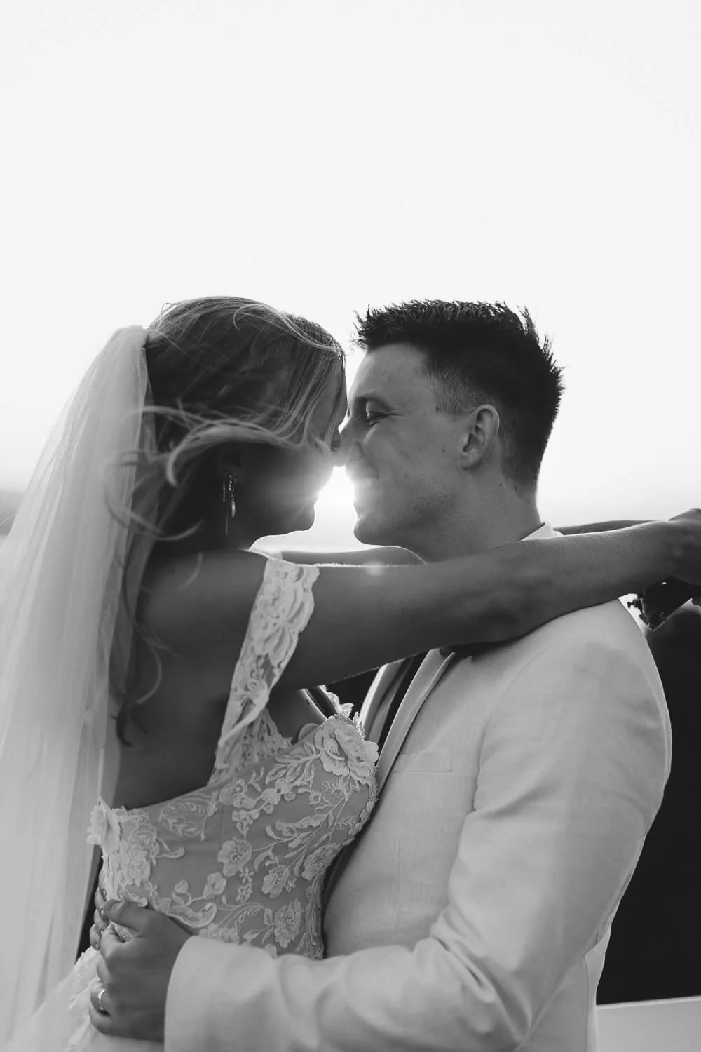 Black and white portrait of a bride and groom kissing at the Byron Bay lighthouse