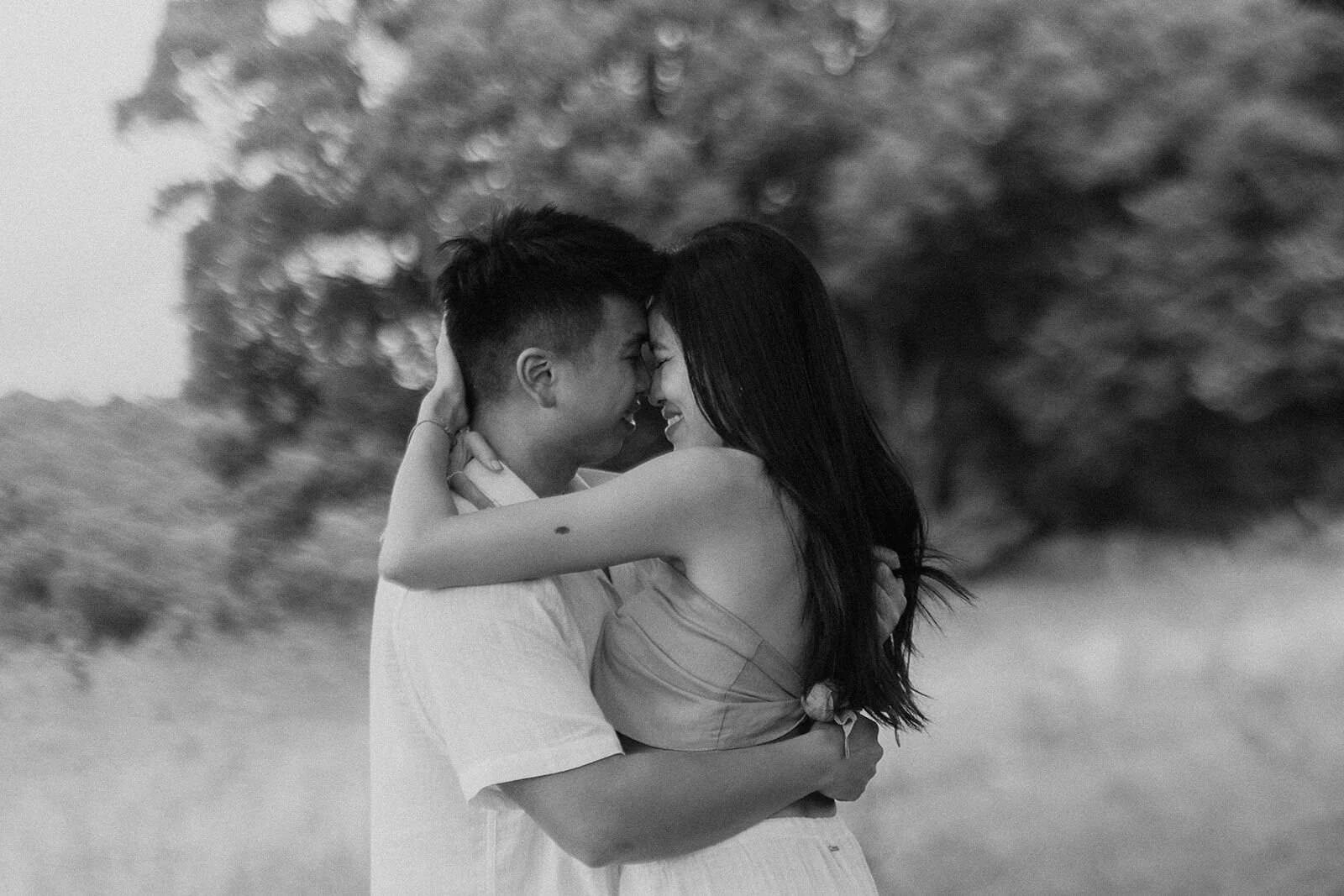 Black and white of the couple embracing with foreheads together, Darien and Jacqui's picnic marriage proposal at Heartwood Farm, Byron Bay hinterland