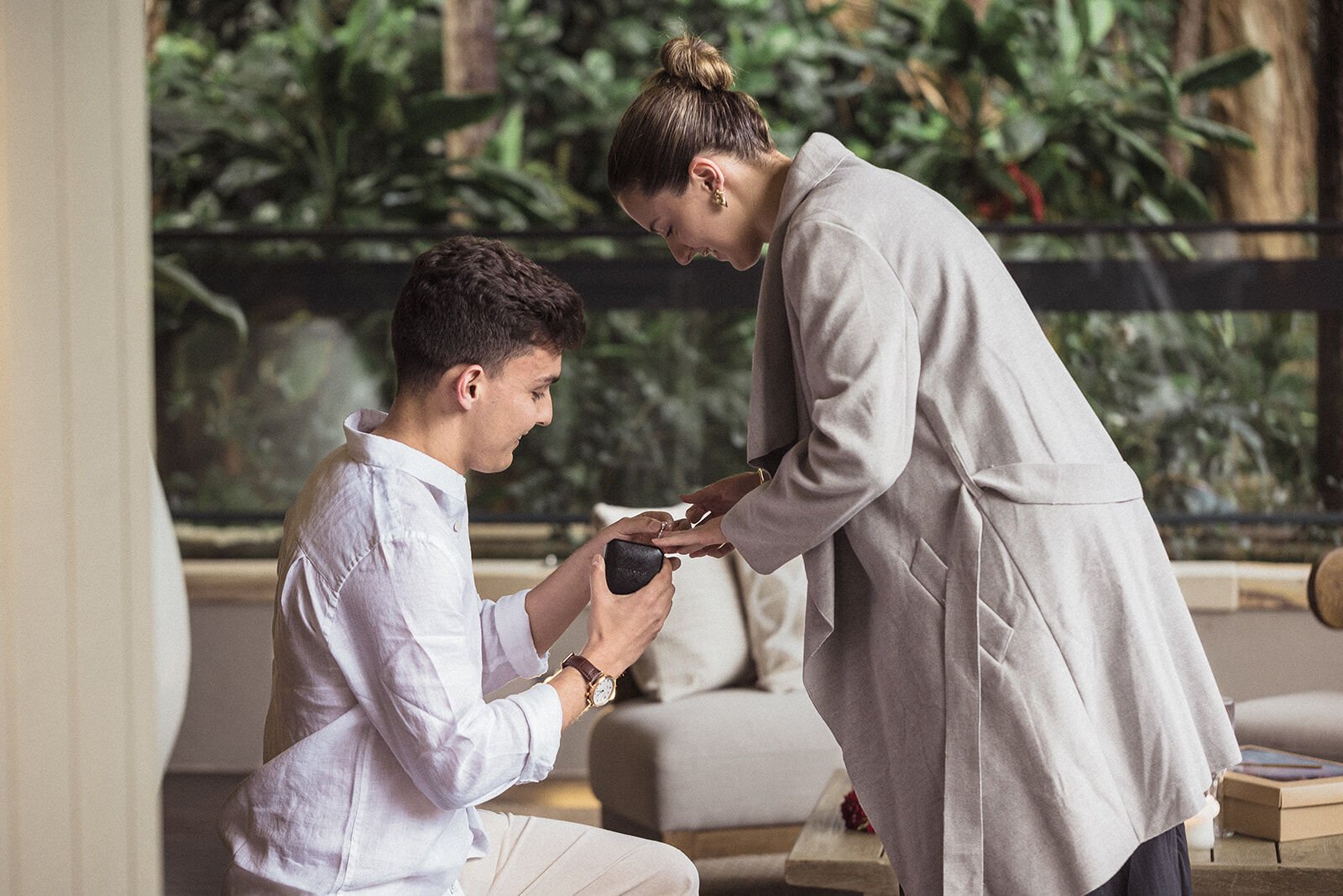 Woman looking at the ring as her partner kneels beside her, Ben and Chloe's marriage proposal in Byron Bay