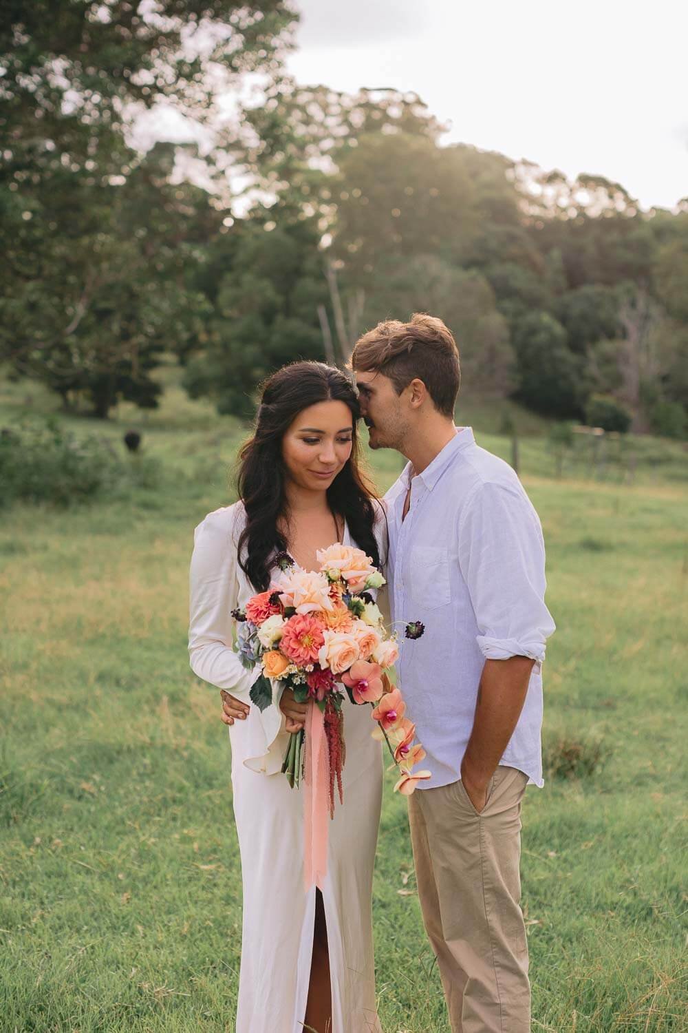 Eloping couple sharing a quiet moment in a Byron hinterland paddock