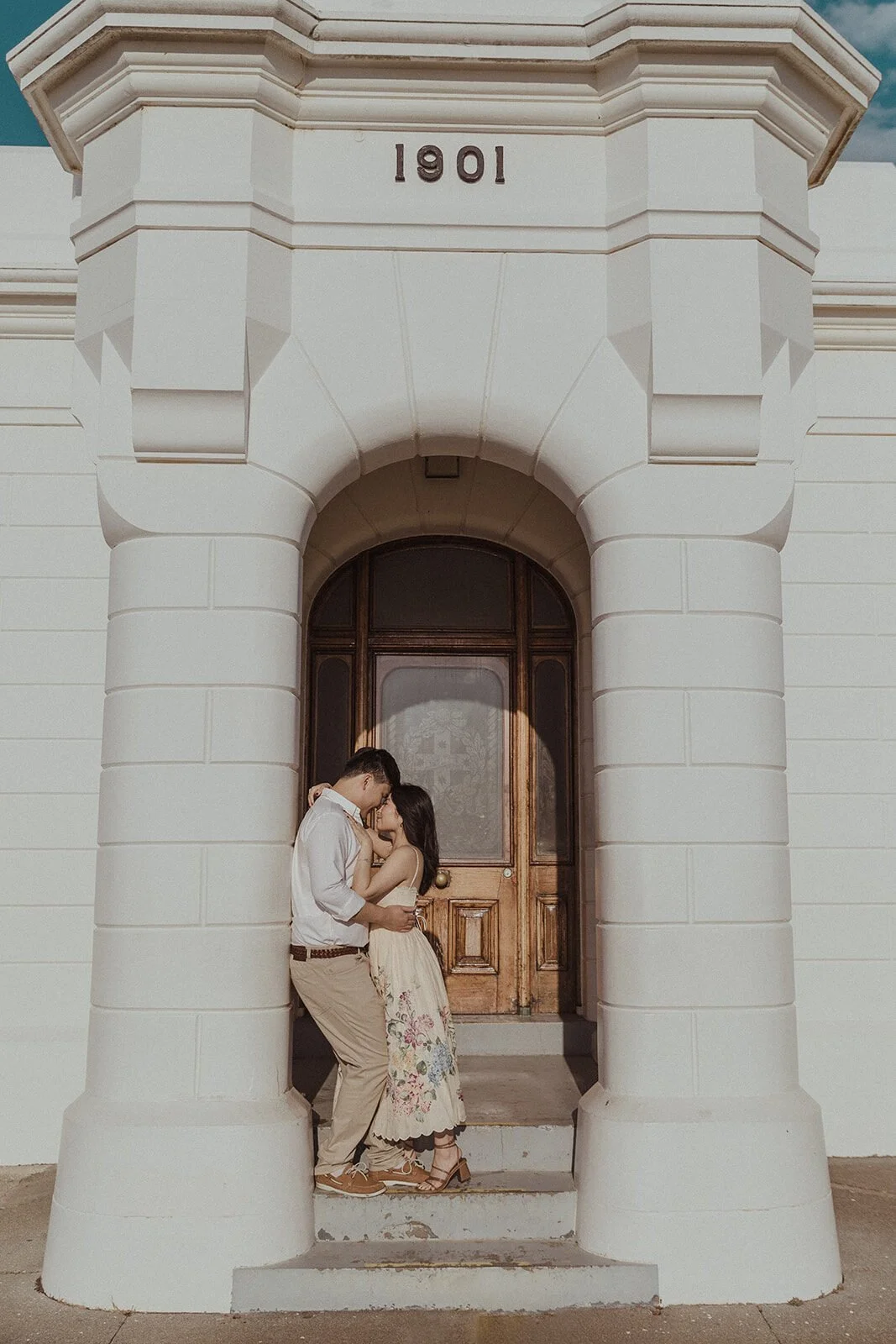 Couple embracing in the lighthouse doorway, Maggie and William's pre-wedding photos in Byron Bay