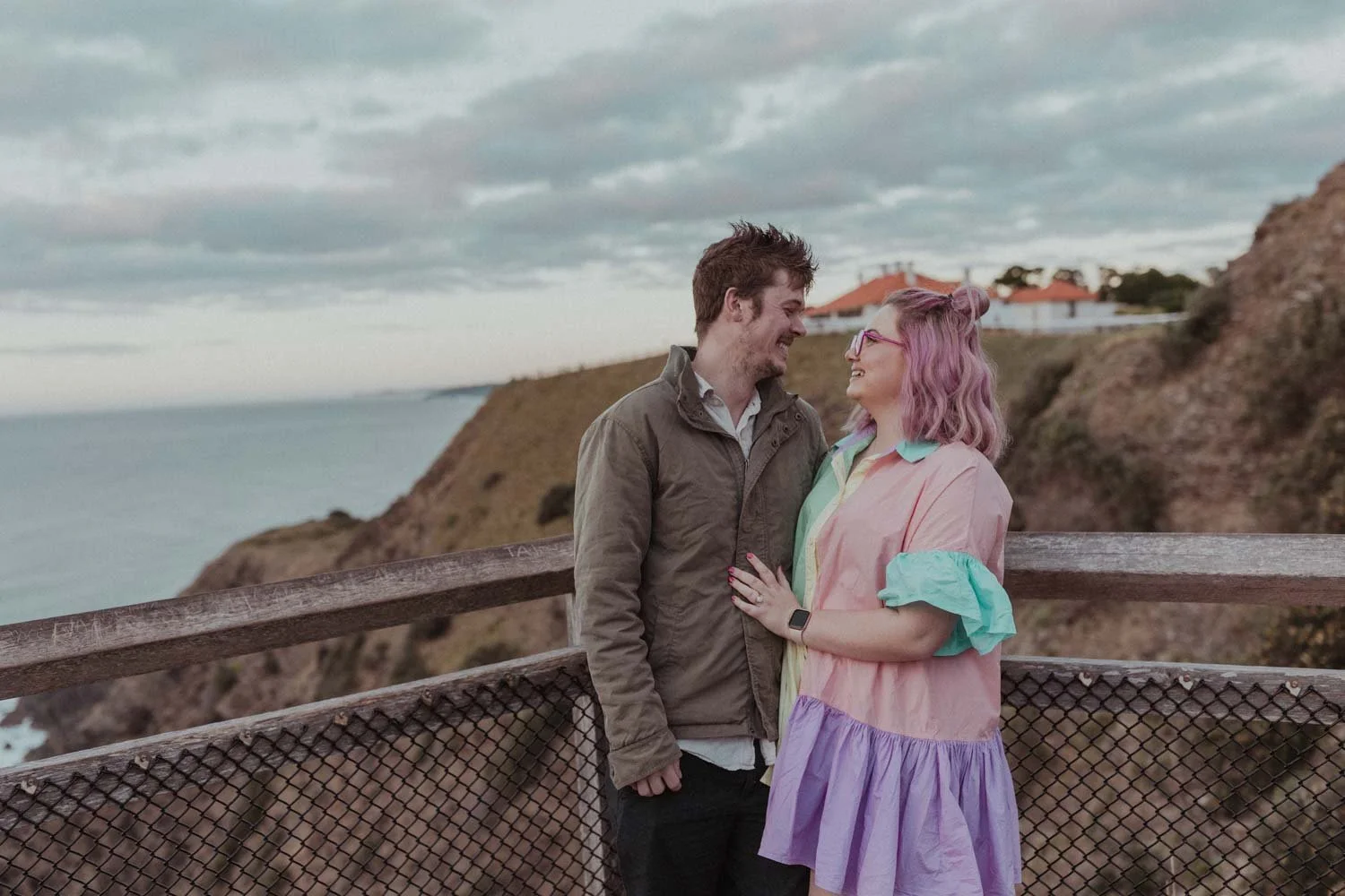 Newly engaged couple laughing at the Cape Byron Lighthouse lookout