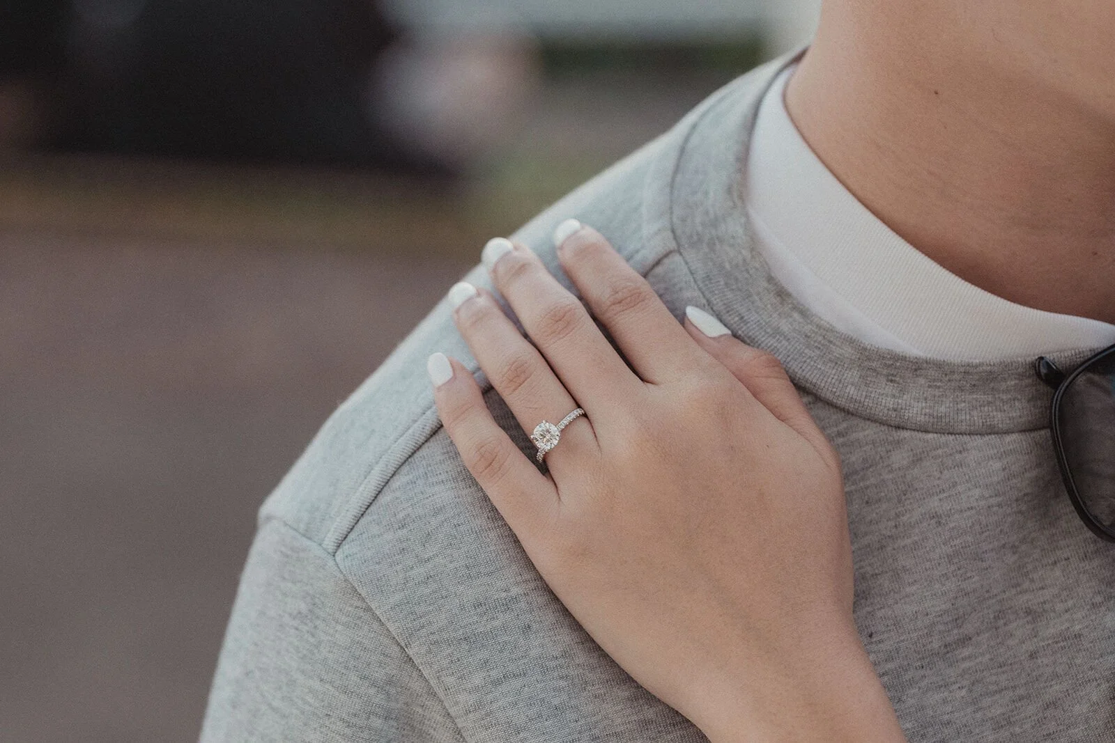 Close up of the engagement ring on her hand resting on his shoulder, Douglas and Ying's sunset marriage proposal at Cape Byron Lighthouse, Byron Bay