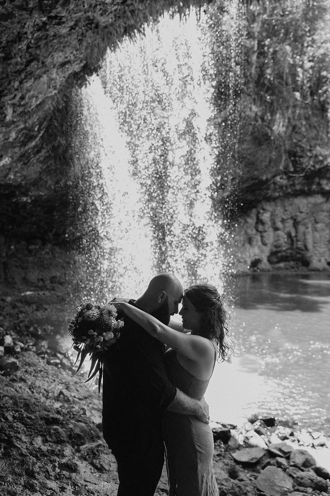 Black and white of the couple embracing under the waterfall, Sara and Graeme's elopement at Killen Falls, Northern Rivers