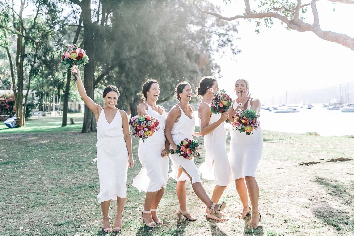 Bridal party gathered in dappled light under the trees at Bilgola Beach