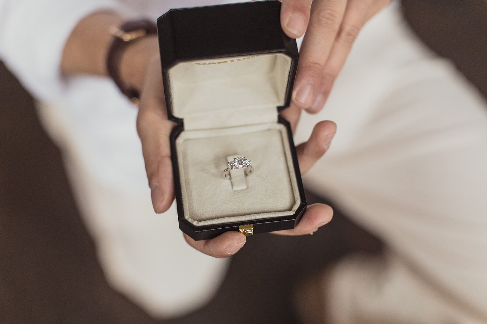 Engagement ring in its box held in his hand, Ben and Chloe's marriage proposal in Byron Bay