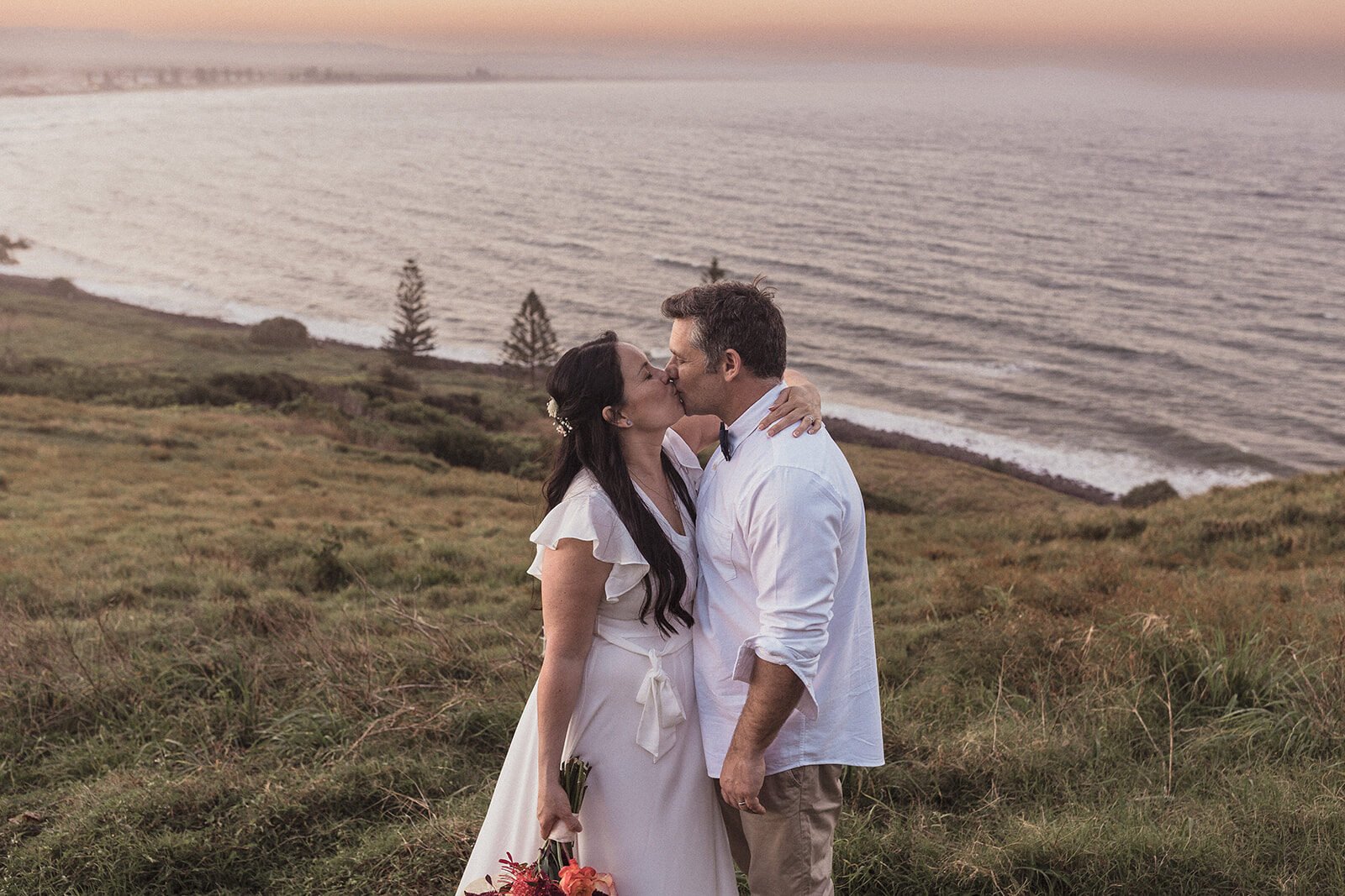 Couple kissing on the hillside, Maritess and Mark's elopement at Lennox Head