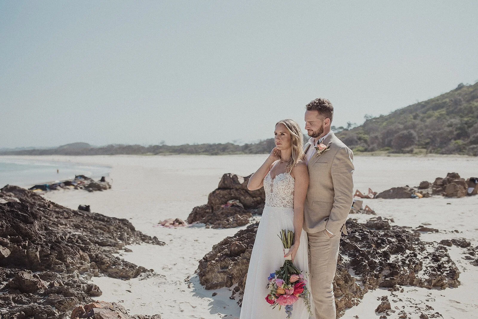 Couple on the beach beside the rocks, Eliza and Greg's elopement at Broken Head, Byron Bay