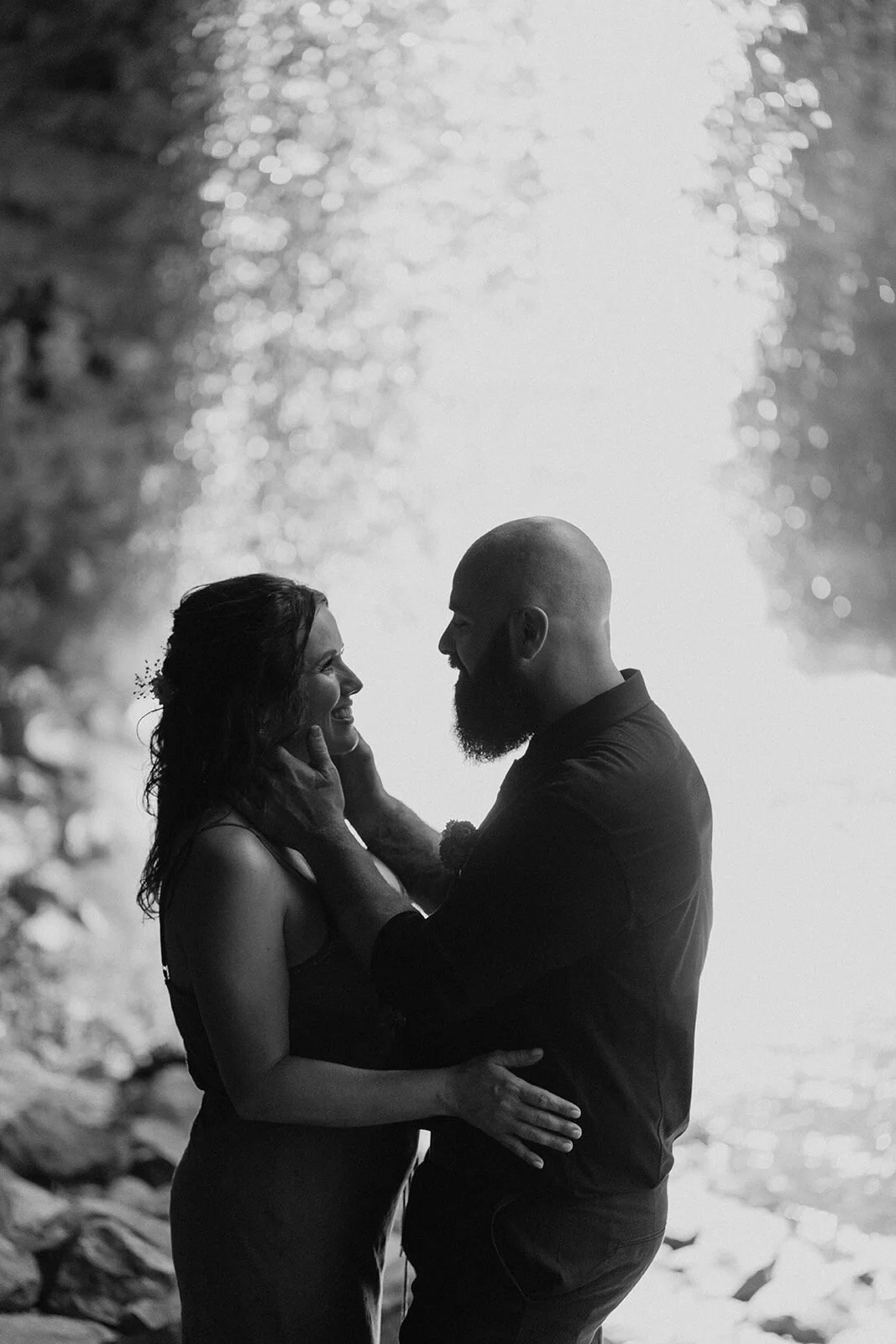 Black and white of the couple embracing backlit by the waterfall, Sara and Graeme's elopement at Killen Falls, Northern Rivers
