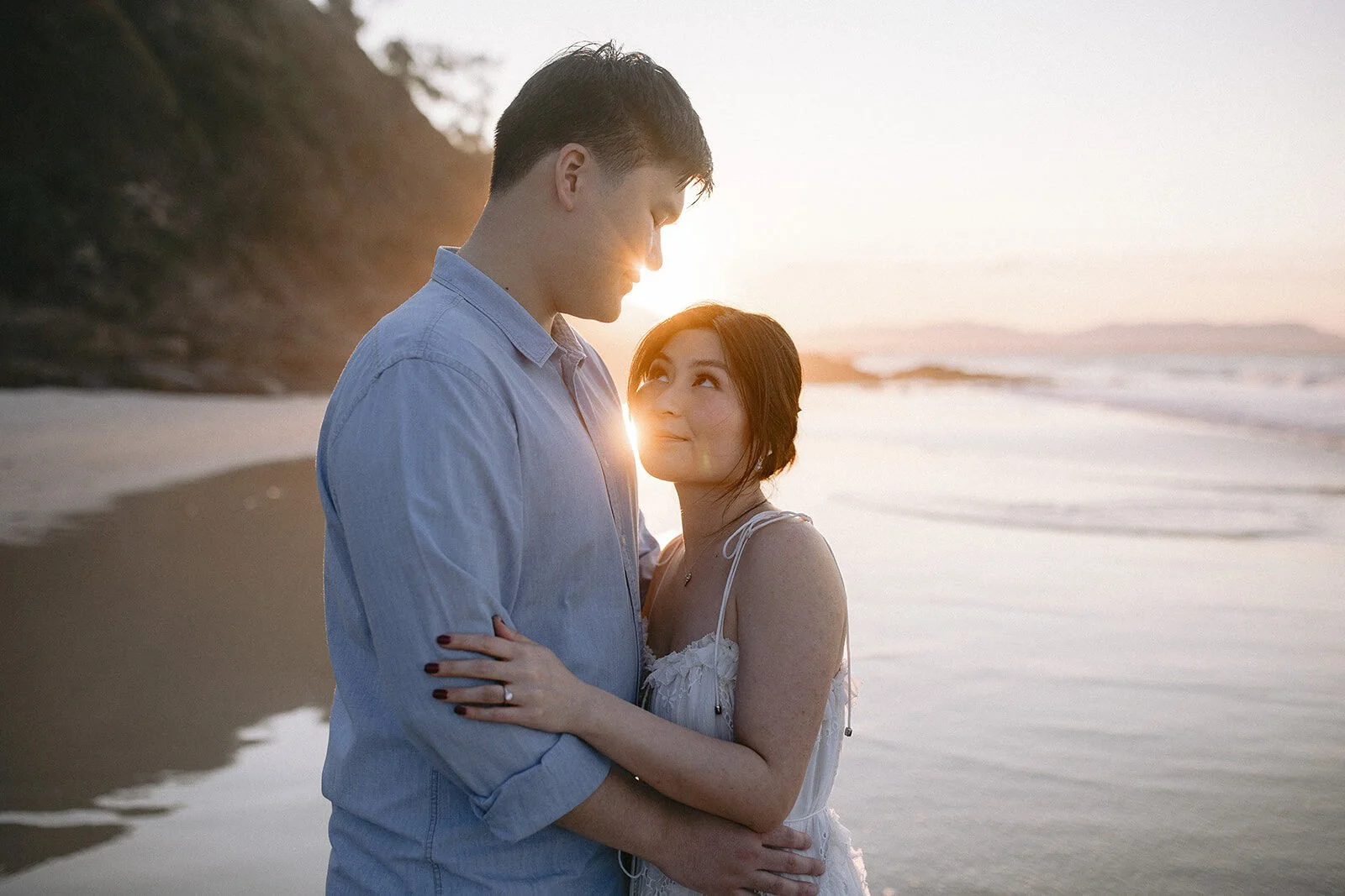 Couple embracing and looking at each other with the sunset behind, Maggie and William's pre-wedding photos in Byron Bay