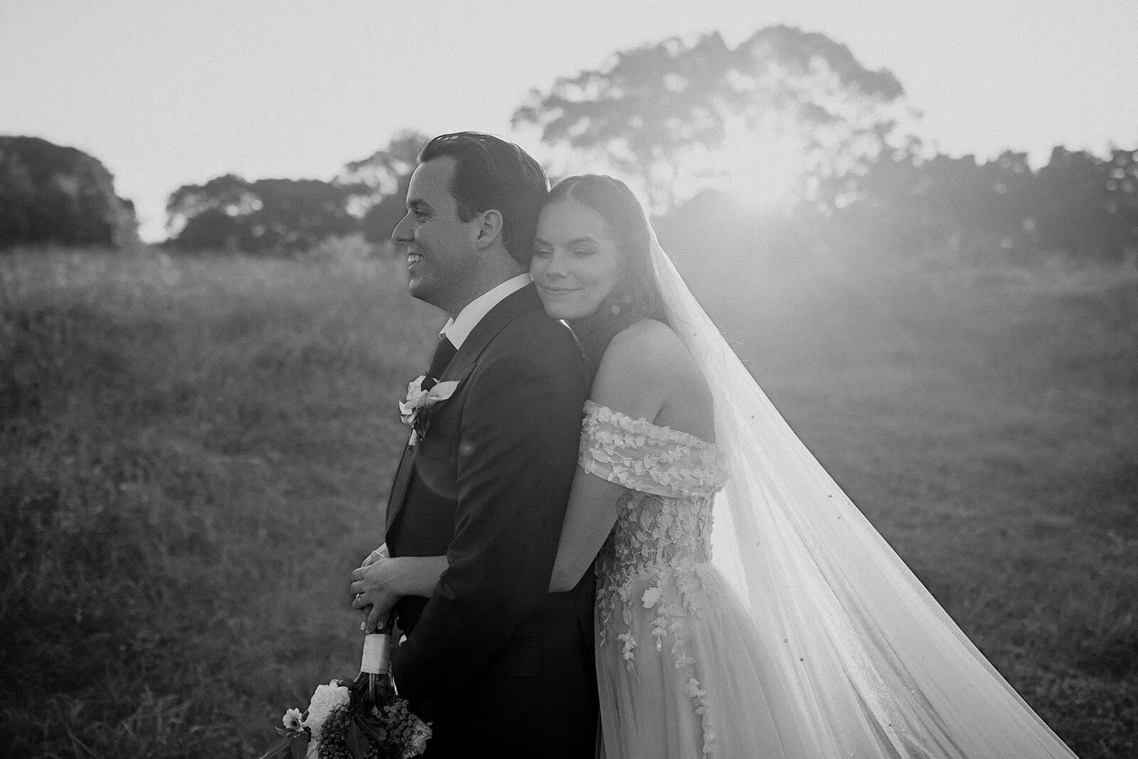 Black and white of the couple laughing in the sunset, Steph and William's wedding at Earth House, Byron Bay