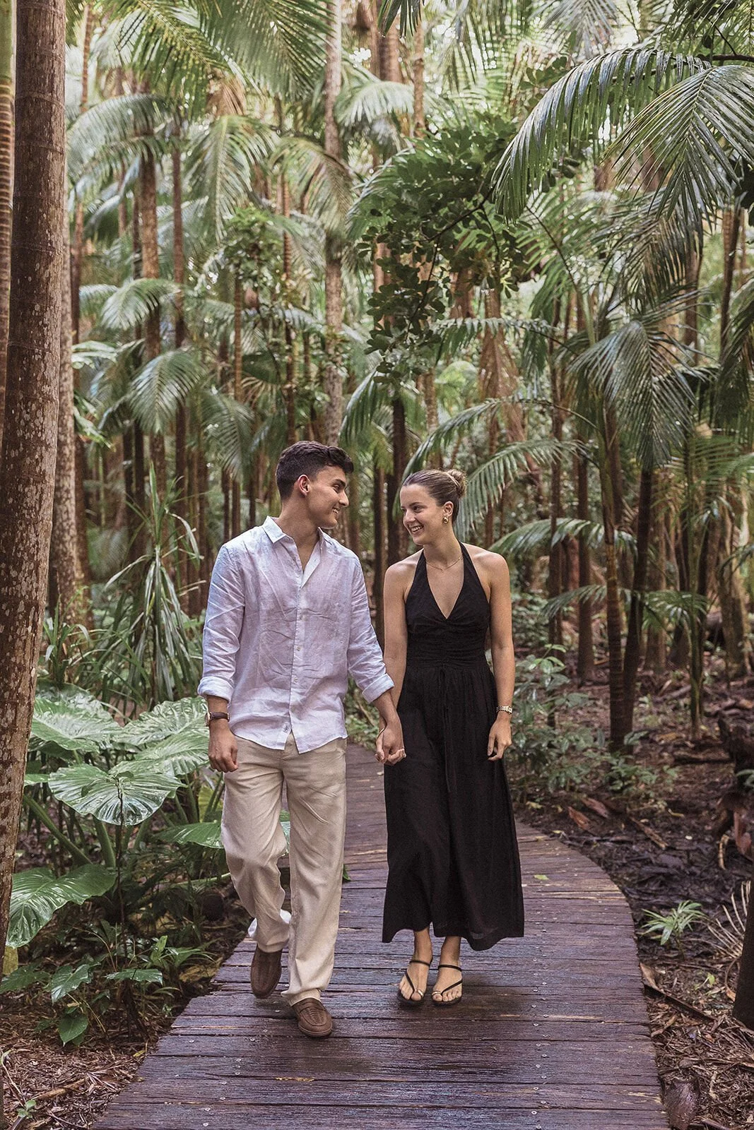 Couple walking hand in hand toward the camera through the rainforest, Ben and Chloe's marriage proposal in Byron Bay