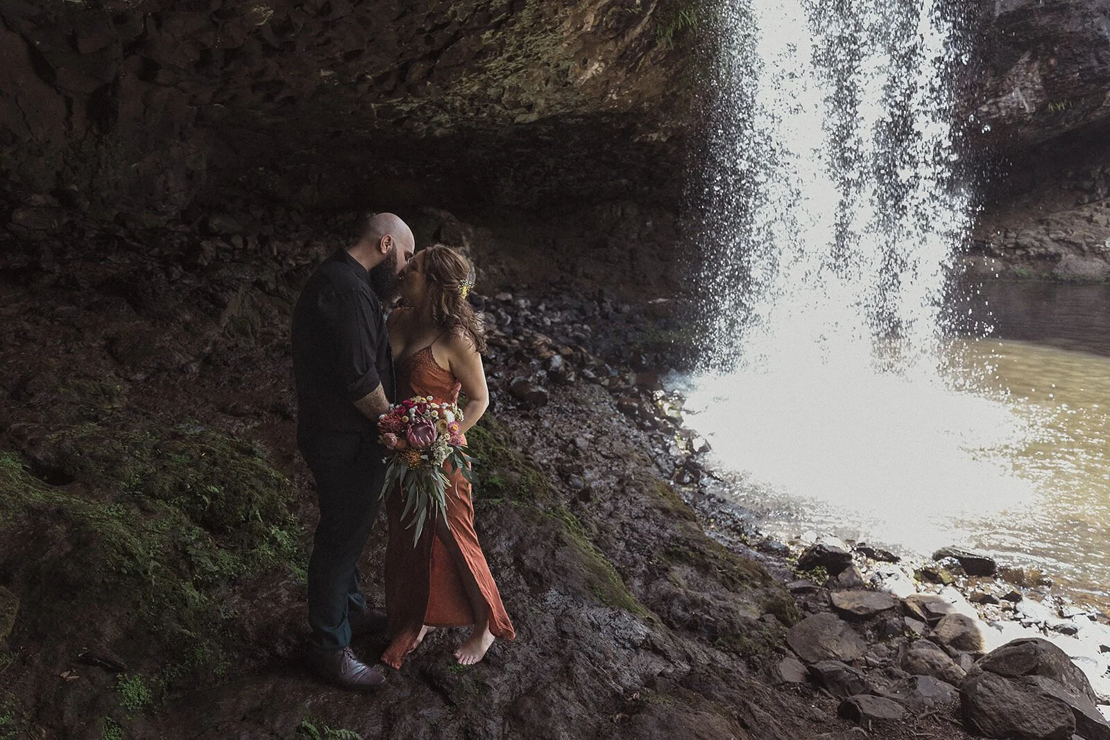 Couple beside the waterfall in the rock cave, Sara and Graeme's elopement at Killen Falls, Northern Rivers