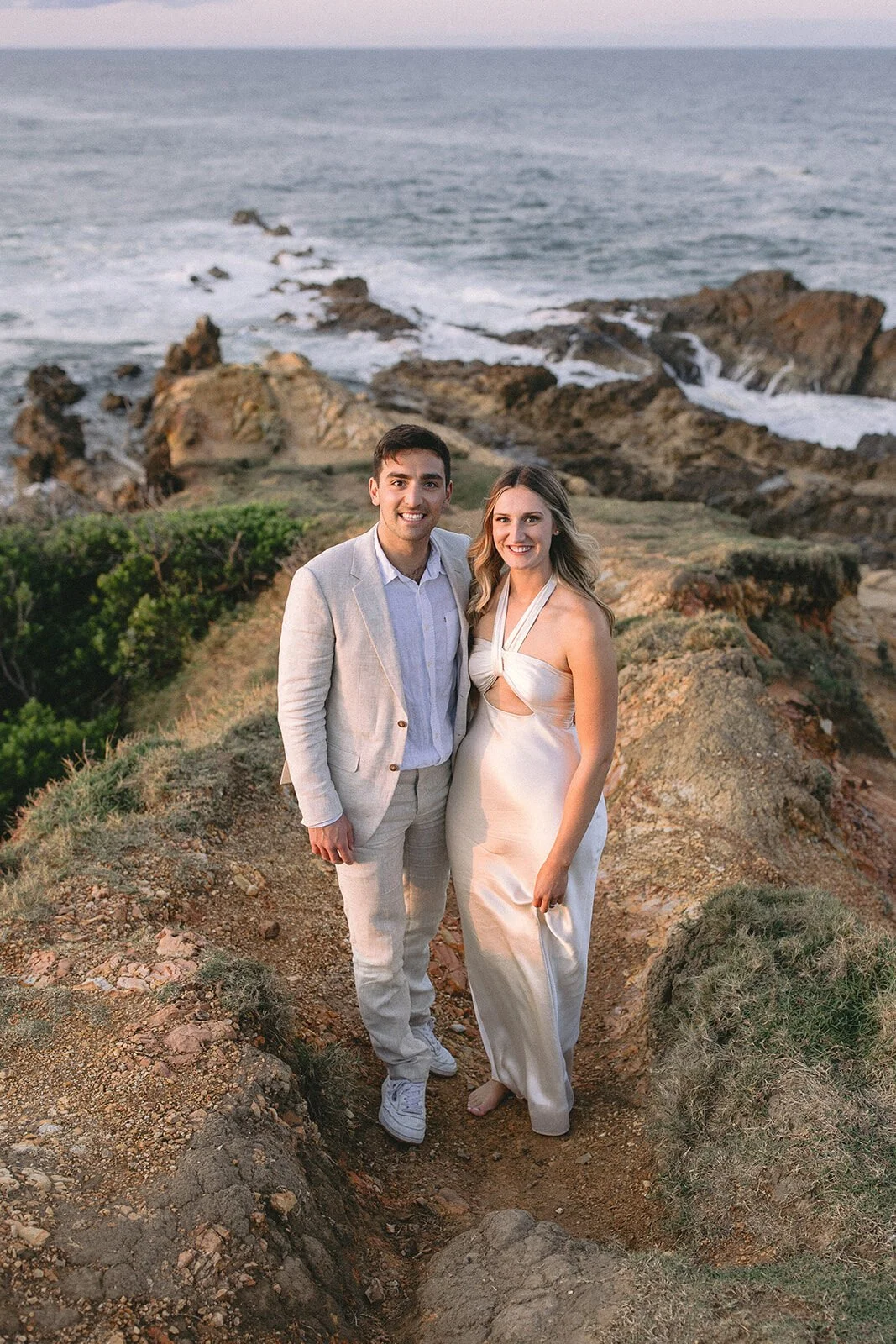 Couple smiling at the camera on the headland, Abby and James' elopement at Little Wategos Beach, Byron Bay