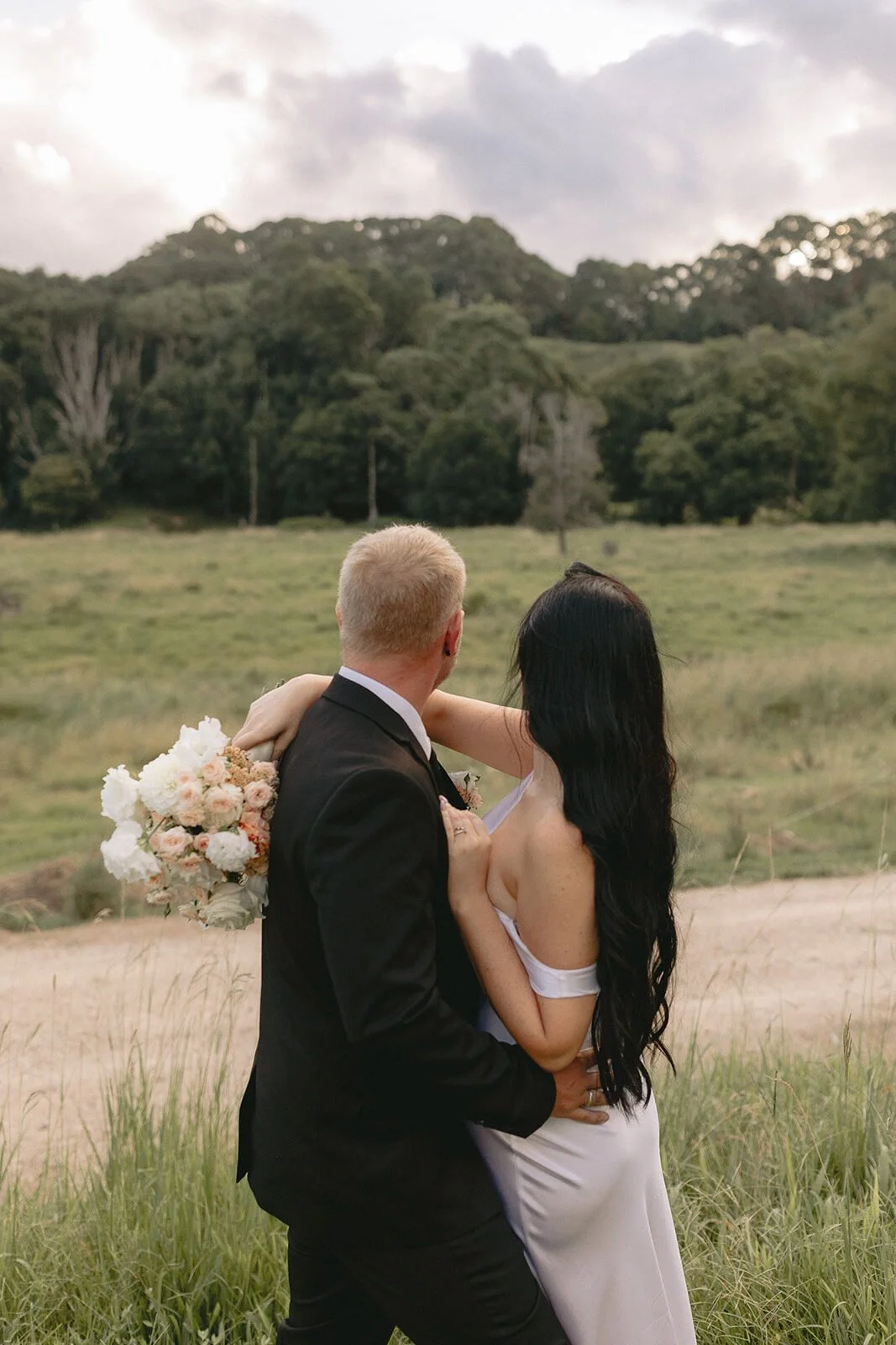 Couple embracing in the paddock, Kobi and Darren's elopement at Butterfly Lane, Byron Bay hinterland