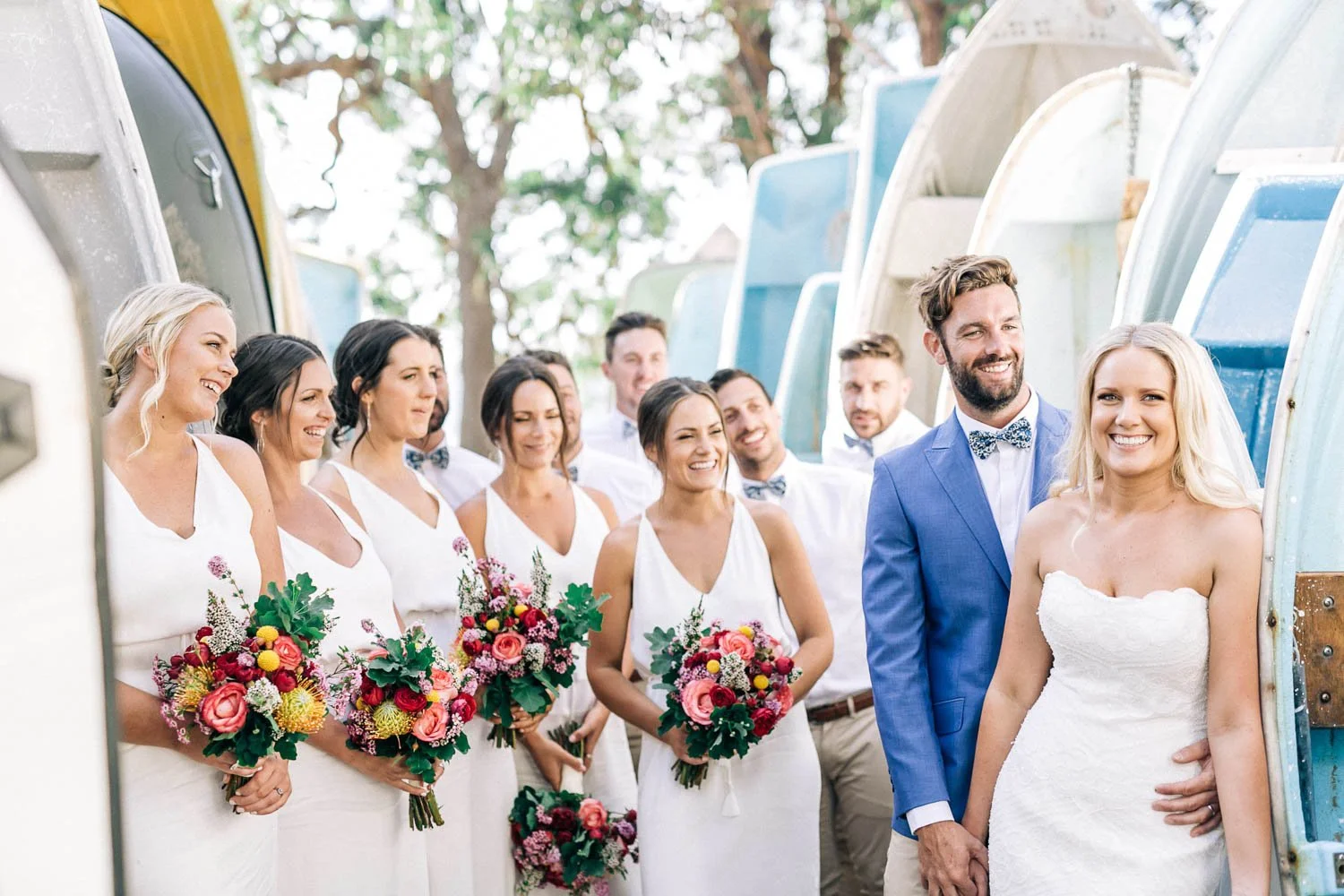 Bride and groom with their bridal party beneath a jacaranda tree at Bilgola