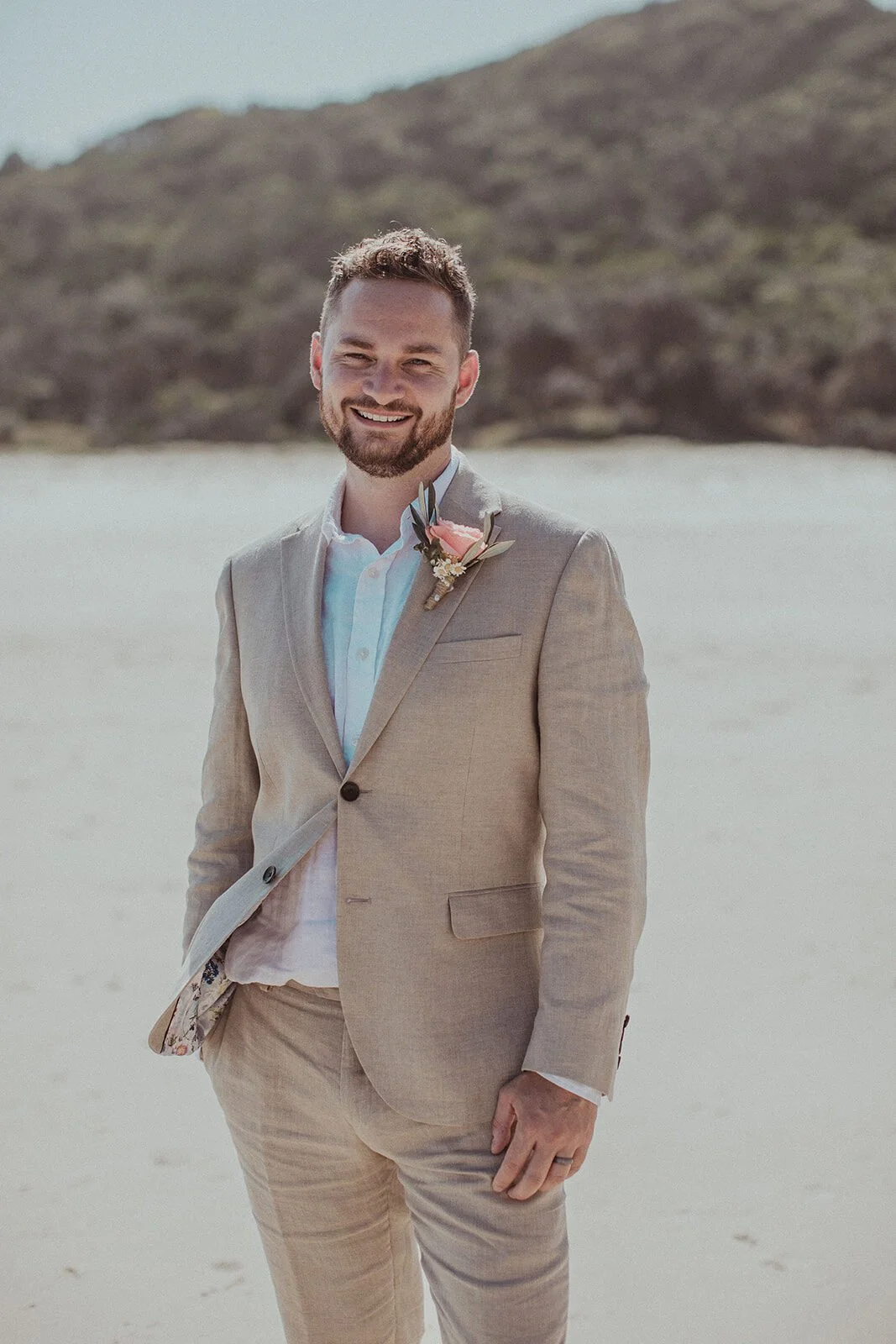 Groom smiling in a linen suit on the beach, Eliza and Greg's elopement at Broken Head, Byron Bay