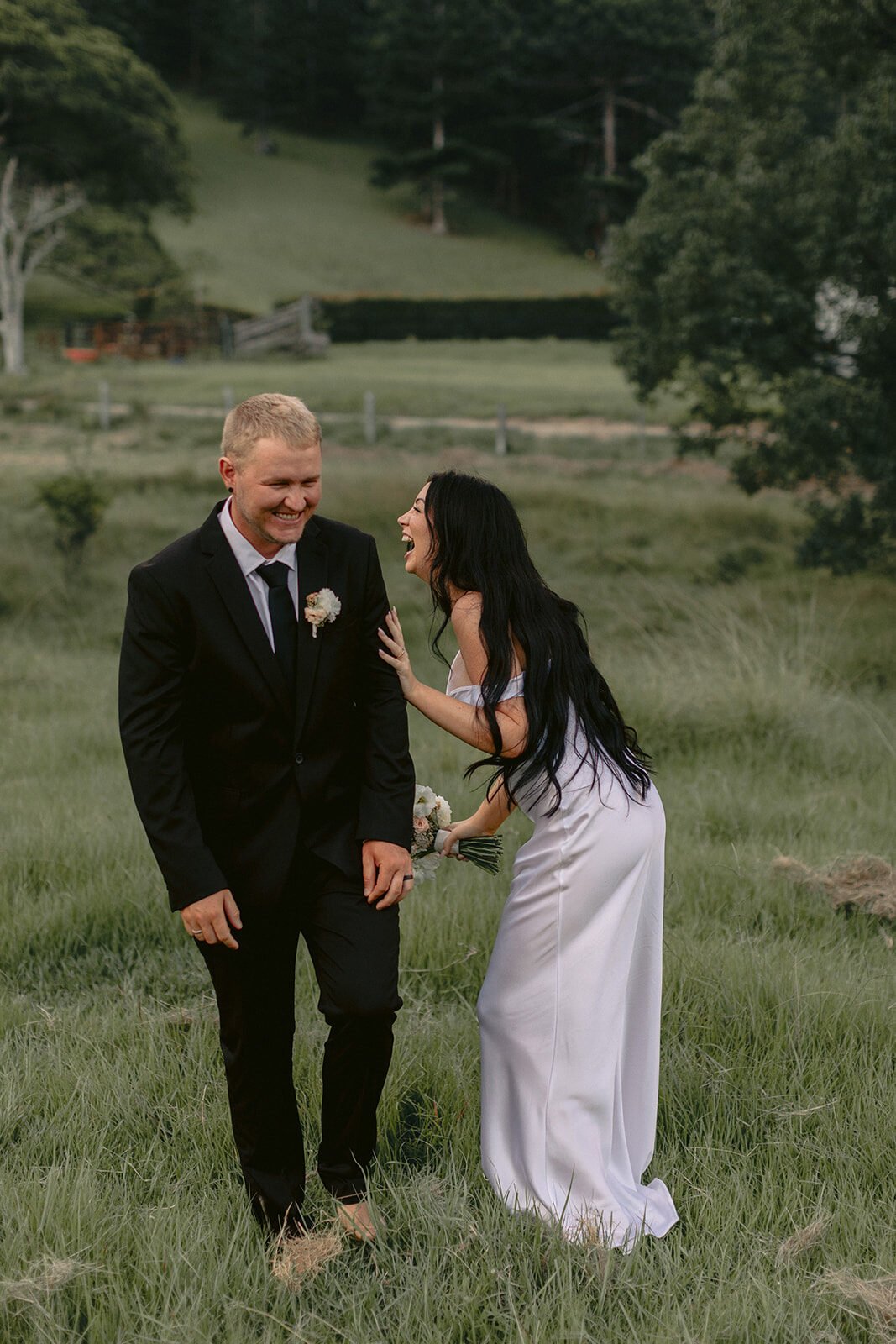Couple laughing in the paddock, Kobi and Darren's elopement at Butterfly Lane, Byron Bay hinterland