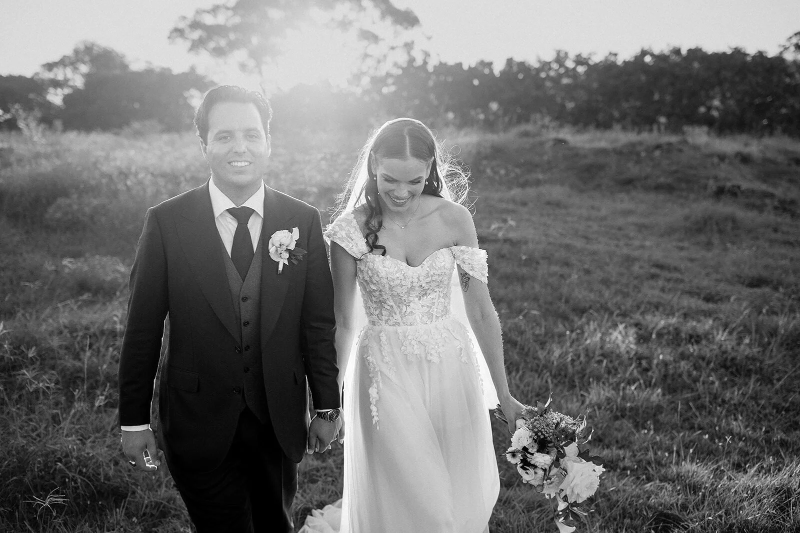 Black and white of the couple walking hand in hand, Steph and William's wedding at Earth House, Byron Bay