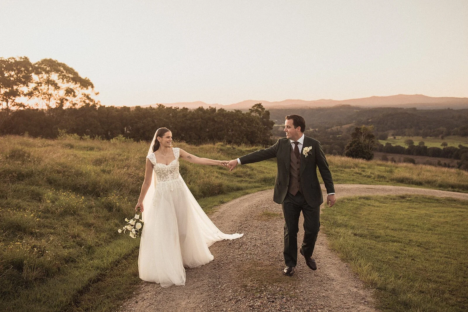 Couple walking a farm track hand in hand, Steph and William's wedding at Earth House, Byron Bay