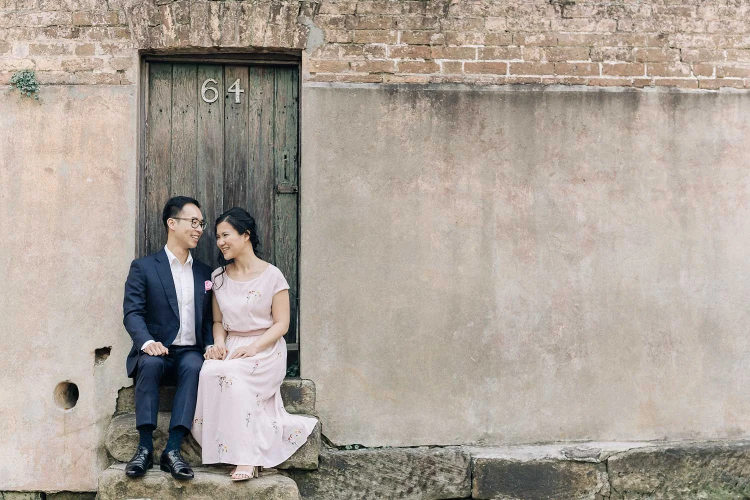 Couple sitting on an old sandstone doorstep in The Rocks, Sydney