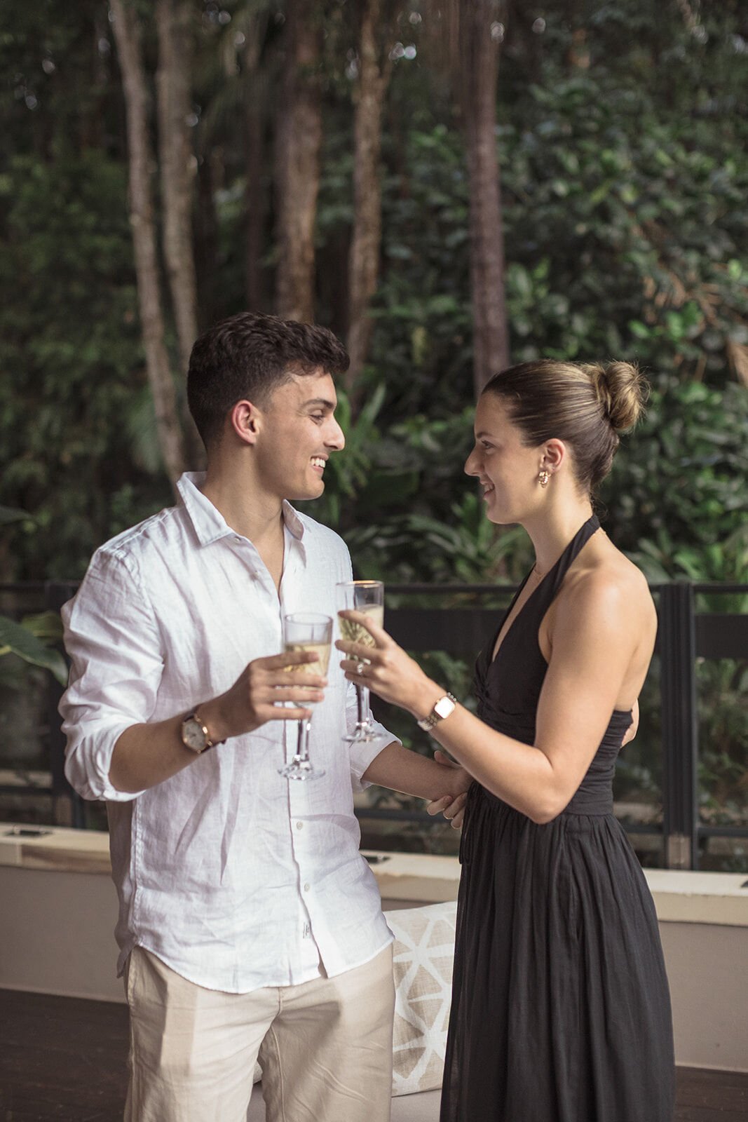Couple toasting with champagne on the deck, Ben and Chloe's marriage proposal in Byron Bay
