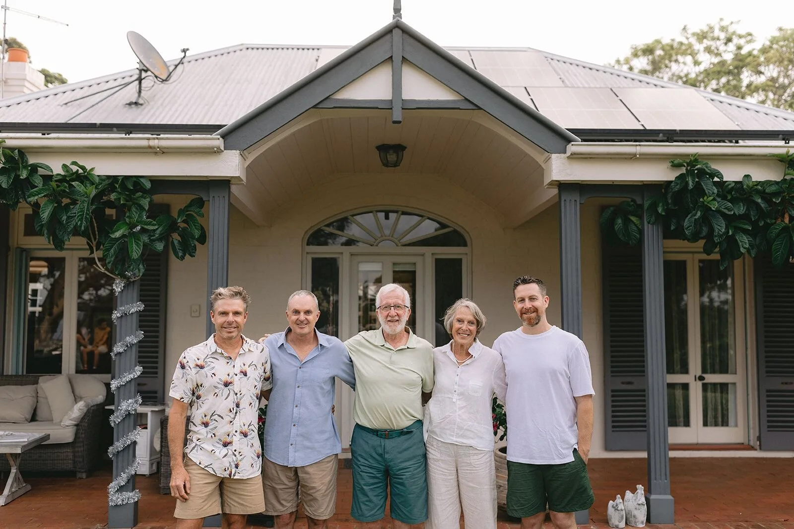 Grandparents with their three sons standing in front of the homestead verandah