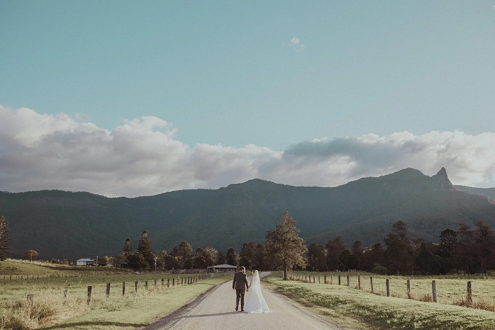 Tiny couple on the road with mountains and clouds, Sam and Tom's elopement at Highfield Farm, Northern Rivers