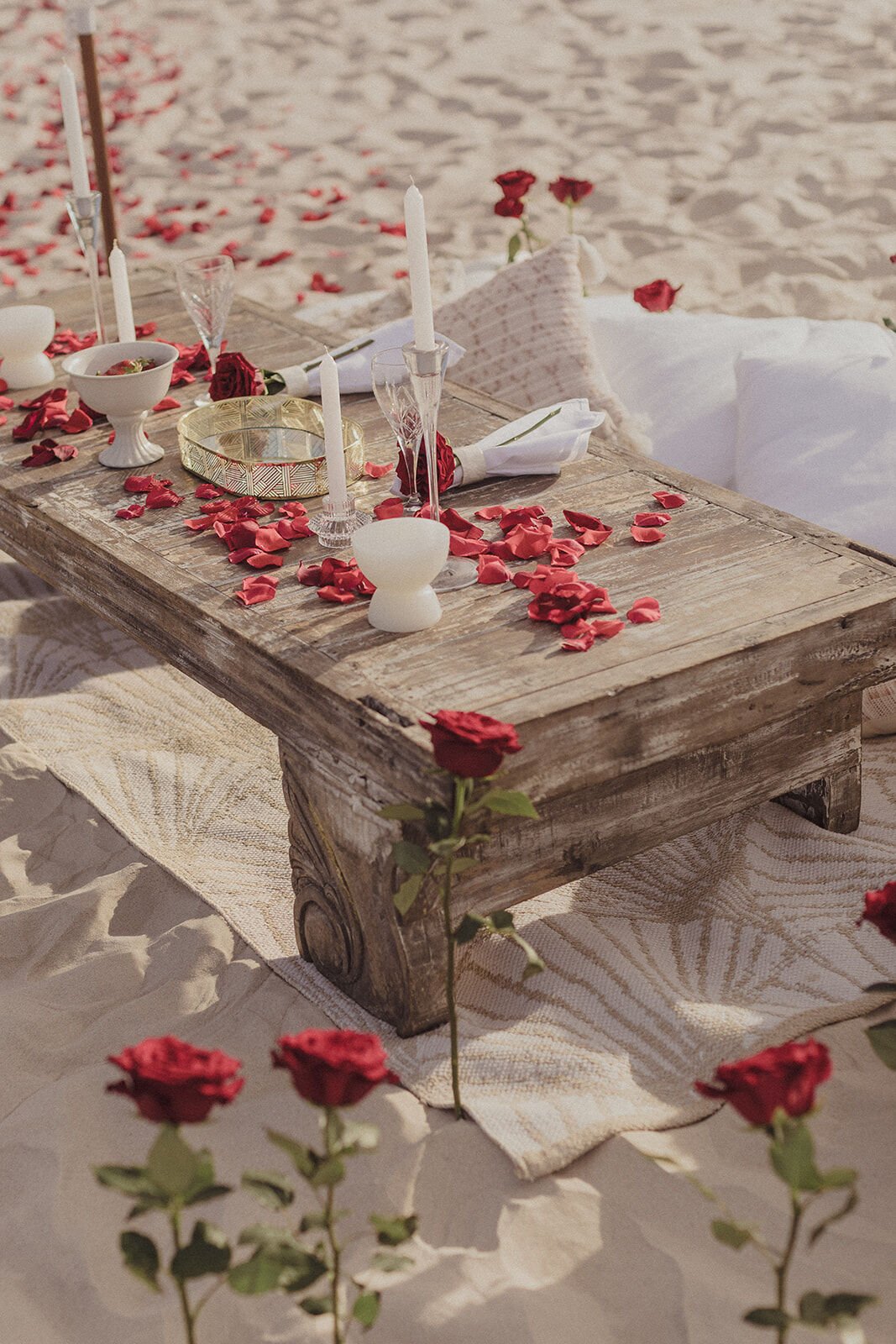 Close view of the beach picnic table scattered with rose petals and candles, Byron and Luke's marriage proposal at Cabarita Beach, Northern Rivers