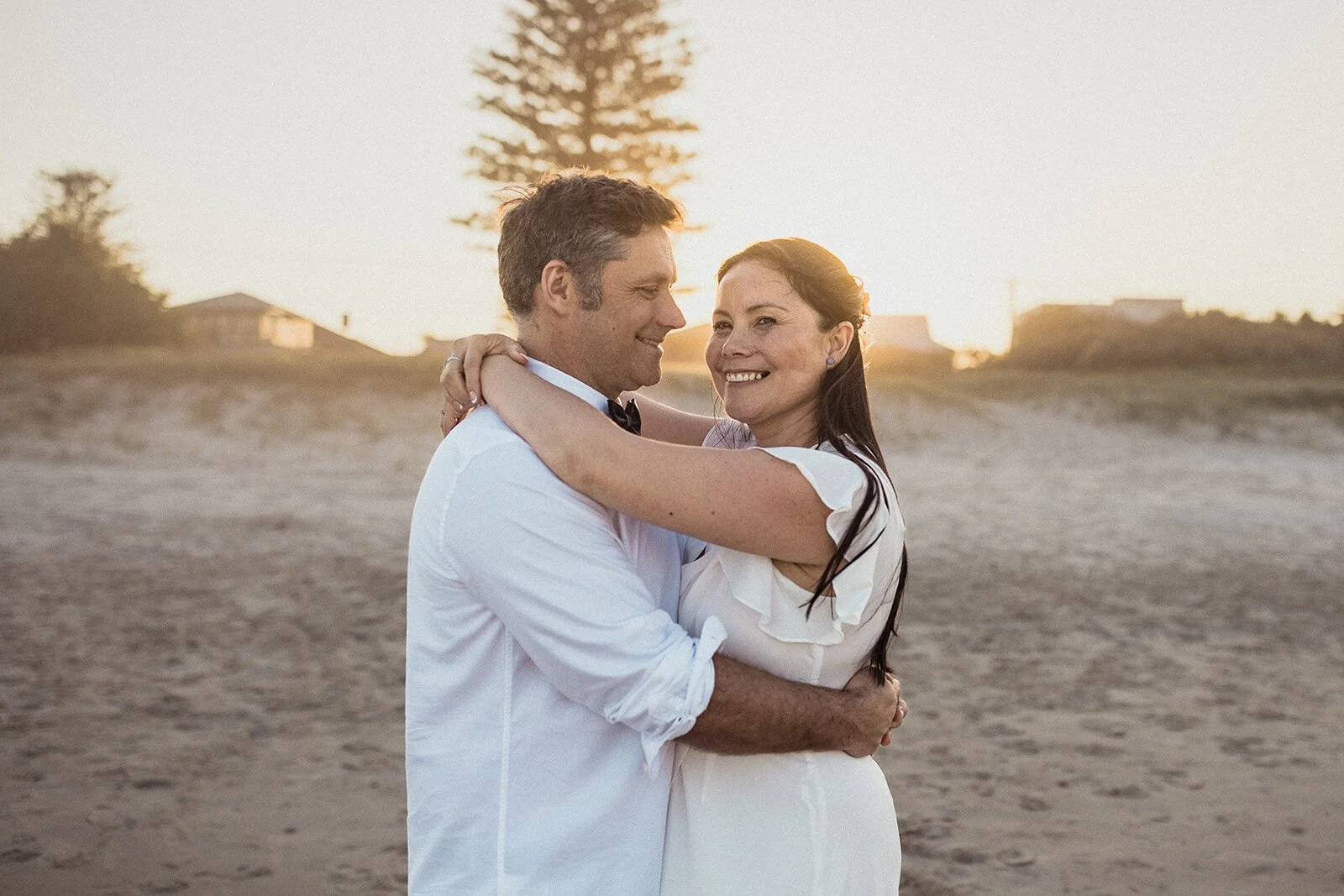 Couple laughing in an embrace on the beach, Maritess and Mark's elopement at Lennox Head