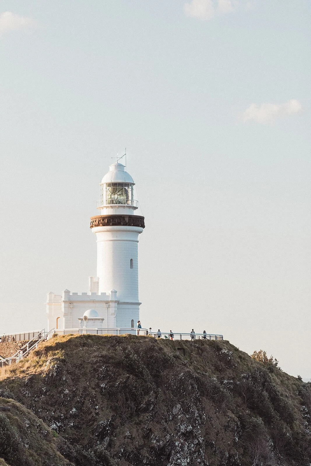 Cape Byron Lighthouse standing on the headland above the ocean, Douglas and Ying's sunset marriage proposal at Cape Byron Lighthouse, Byron Bay